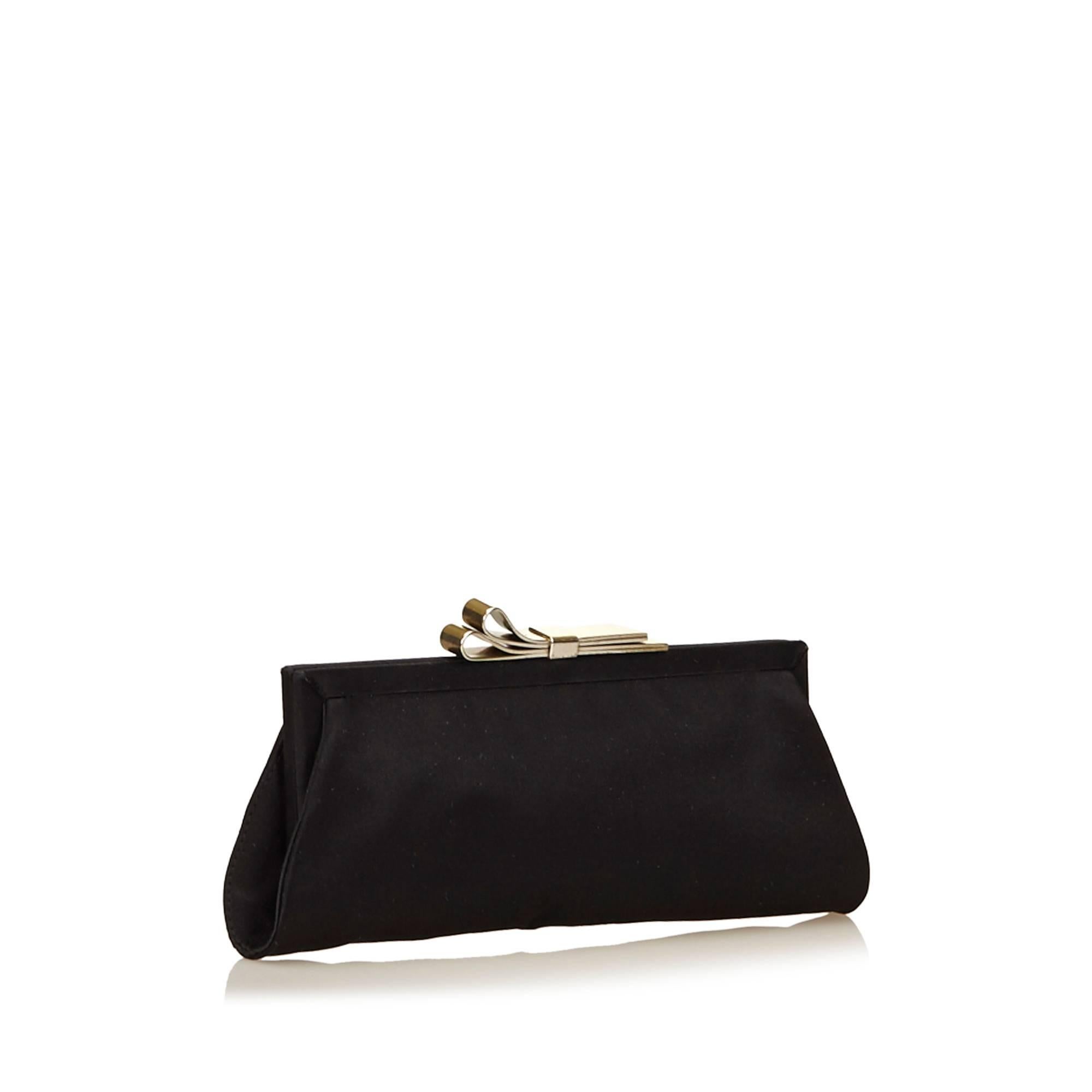 This clutch features a nylon body, a metal frame, and a kiss lock closure.
