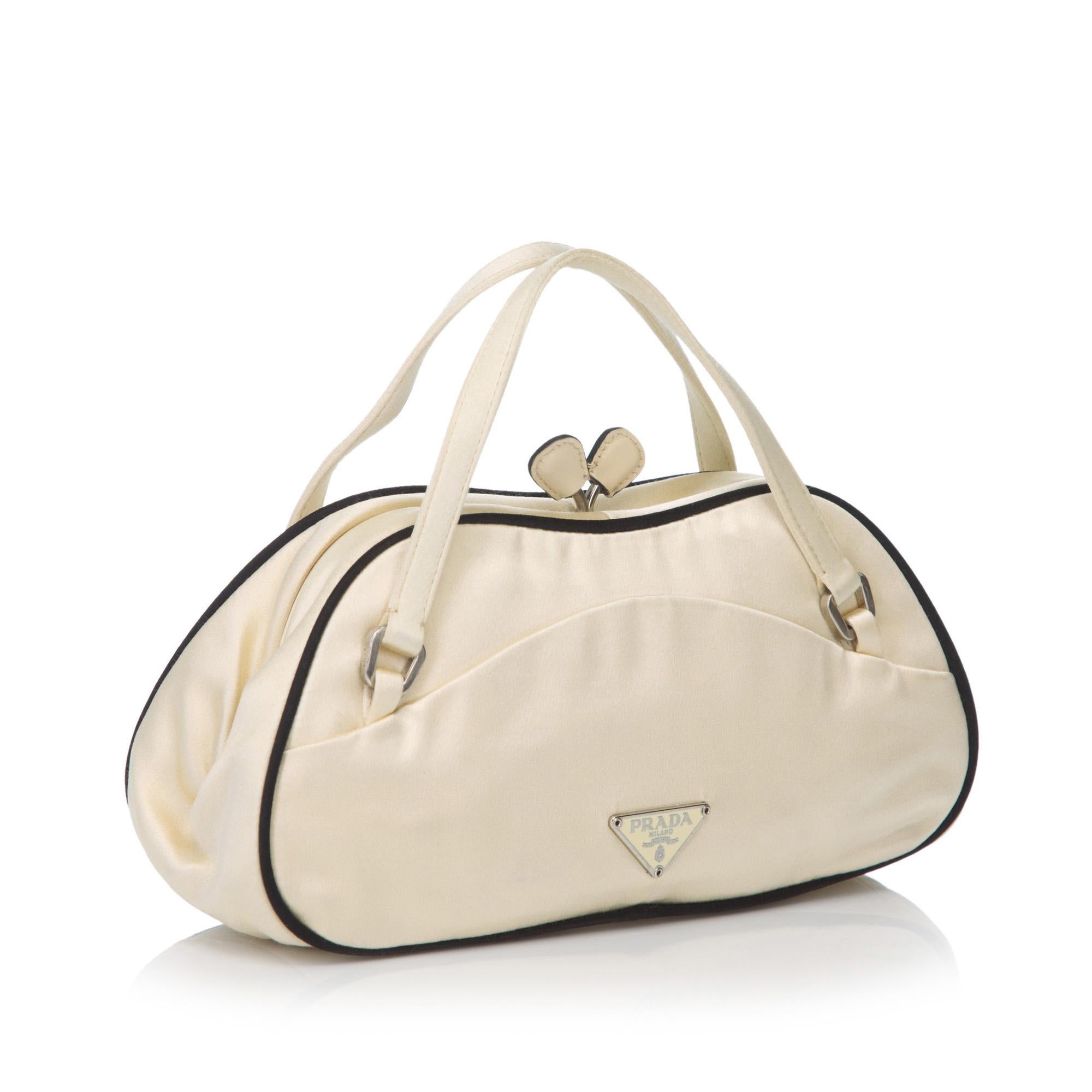 This handbag features a satin body, flat handles, kiss lock closure, and interior slip pocket. It carries as B+ condition rating.

Inclusions: 
Dust Bag

Dimensions:
Length: 21.50 cm
Width: 10.50 cm
Depth: 7.00 cm
Hand Drop: 6.00 cm

Material: