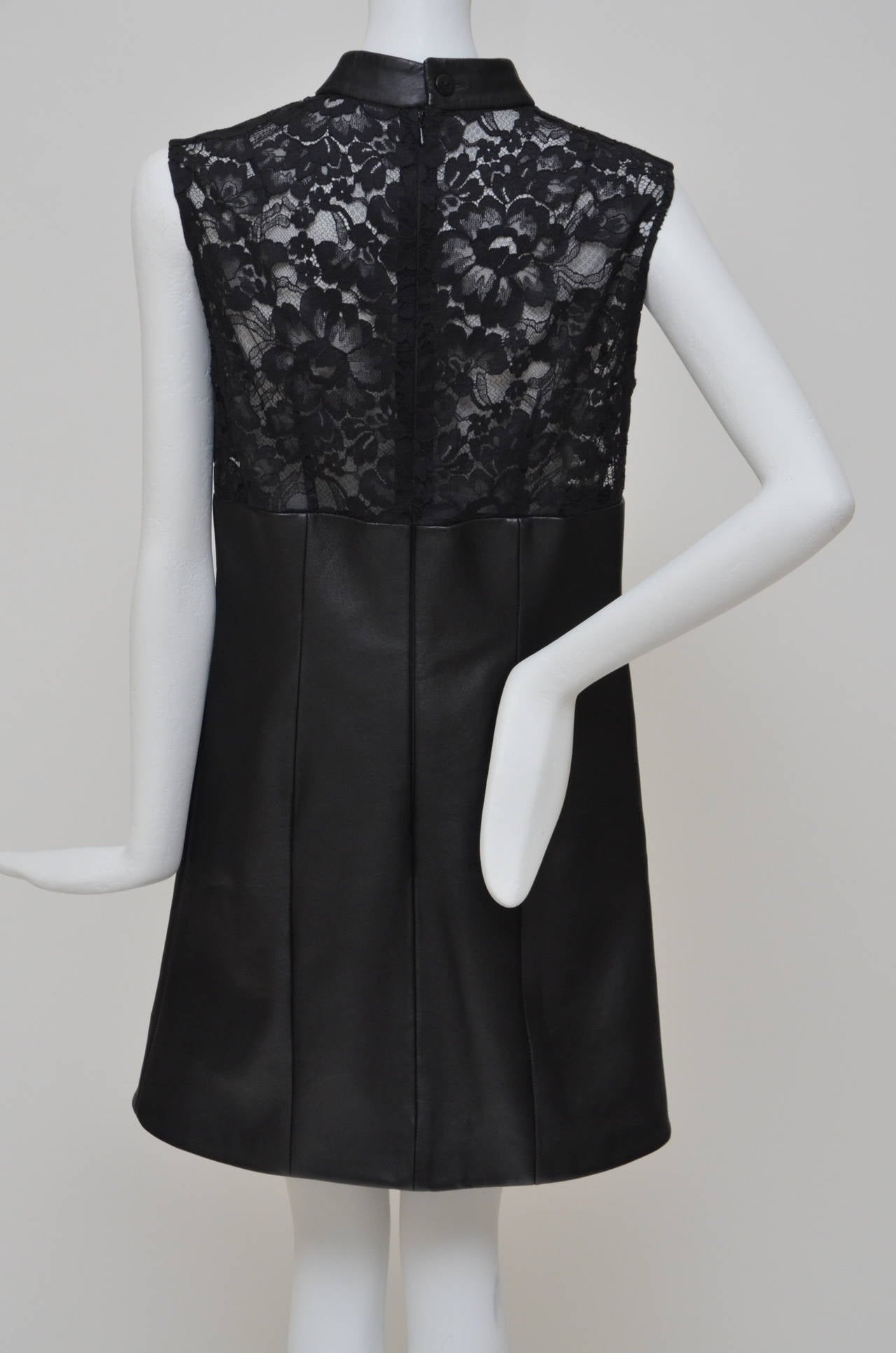 Black leather and lace dress with embroidered floral detail. Christopher Kane dress is sleeveless, has a leather collar, a concealed zip fastening at back, an exposed button fastening at nape of neck, darts at front and back and is partially lined.