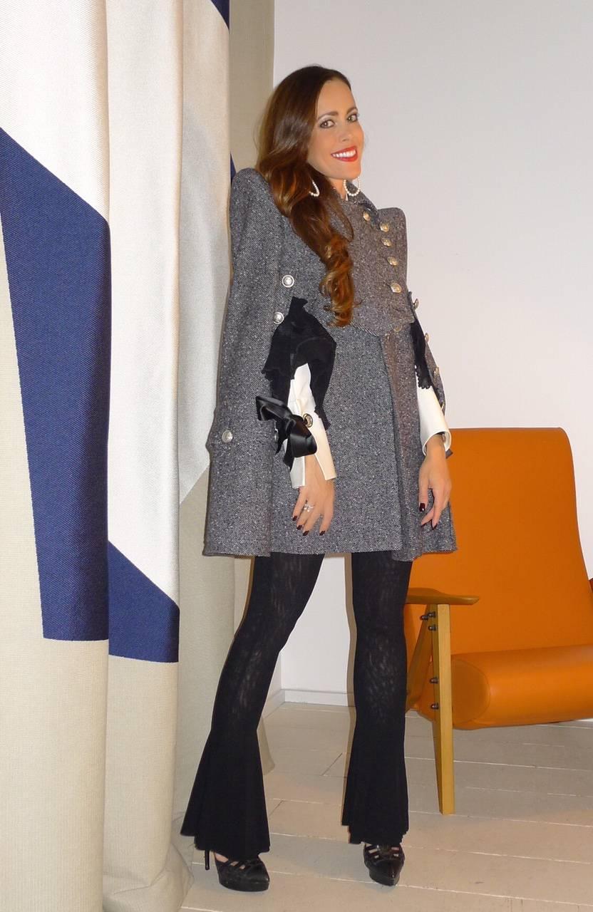 Balmain's gray tweed military cape is the ultimate in directional fall styling. 
Gray tweed military-style cape with structured shoulders. Balmain cape is fully lined, has a collar, silver engraved button detailing, two front armholes, two large