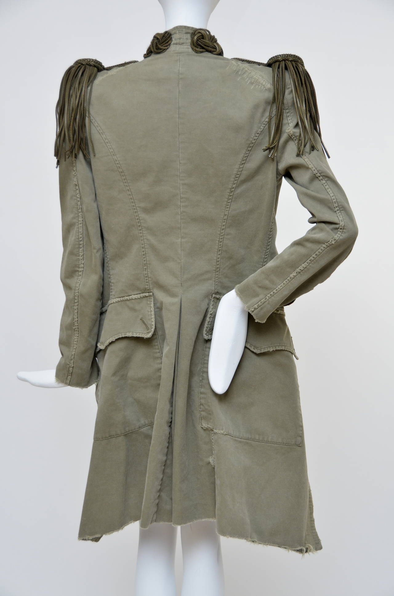 Balmain runway 2010 collection by Christophe Decarnin collection army-green cotton jacket with padded shoulders and zip-chain epaulets. Balmain jacket is collarless, has long sleeves, woven zips around the neckline and on the sleeves, a frayed trim