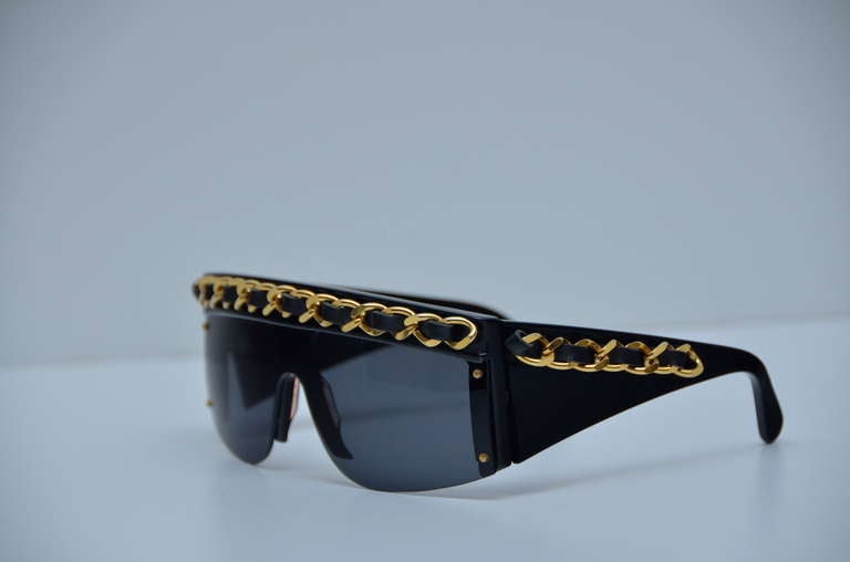 Chanel Vintage Condition Sunglasses As Seen On Lady Gaga.
Mint hard to find  condition  as  new.
Black Chanel shield sunglasses with leather and gold-tone chain link braided trim.Not heavy to wear at all.Craftsmanship on this sunglasess is so