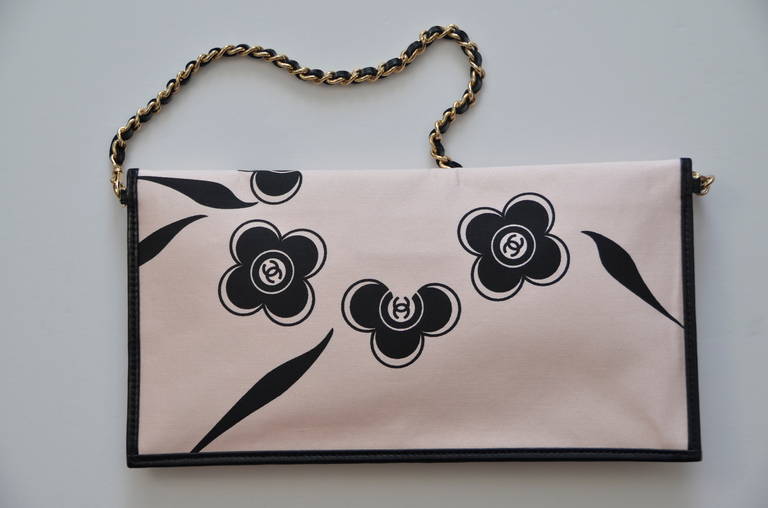 Chanel camellia print handbag/clutch.This handbag could be used as a  clutch or a shoulder bag with the removable strap.White satin fabric with black Camellia flowers printed throughout with iconic 'CC' logo at center, gold tone and black leather