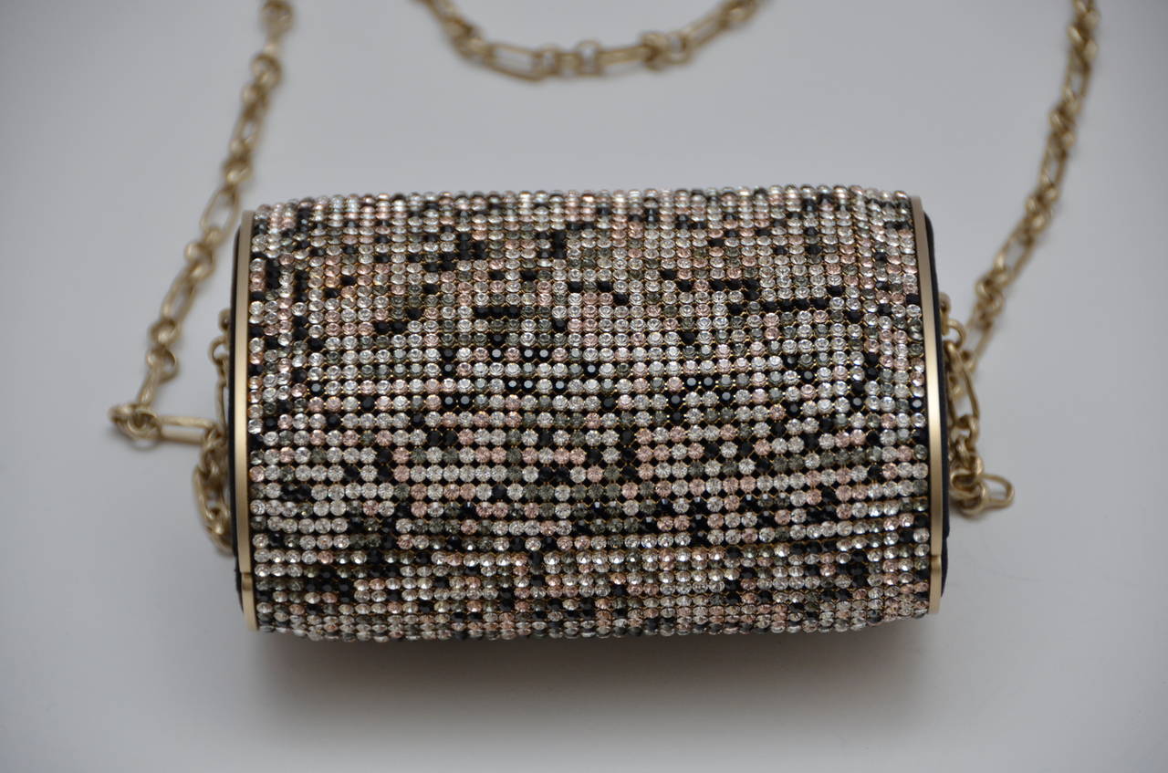 CHANEL Swarovski Crystal Evening Bag in Black and Gold. This stunning hard clutch is completely encrusted with Swarovski crystals.Satin fabric on the booth sides of the bag  and inside lining.Hologram inside and Chanel Made in France metal tag.No
