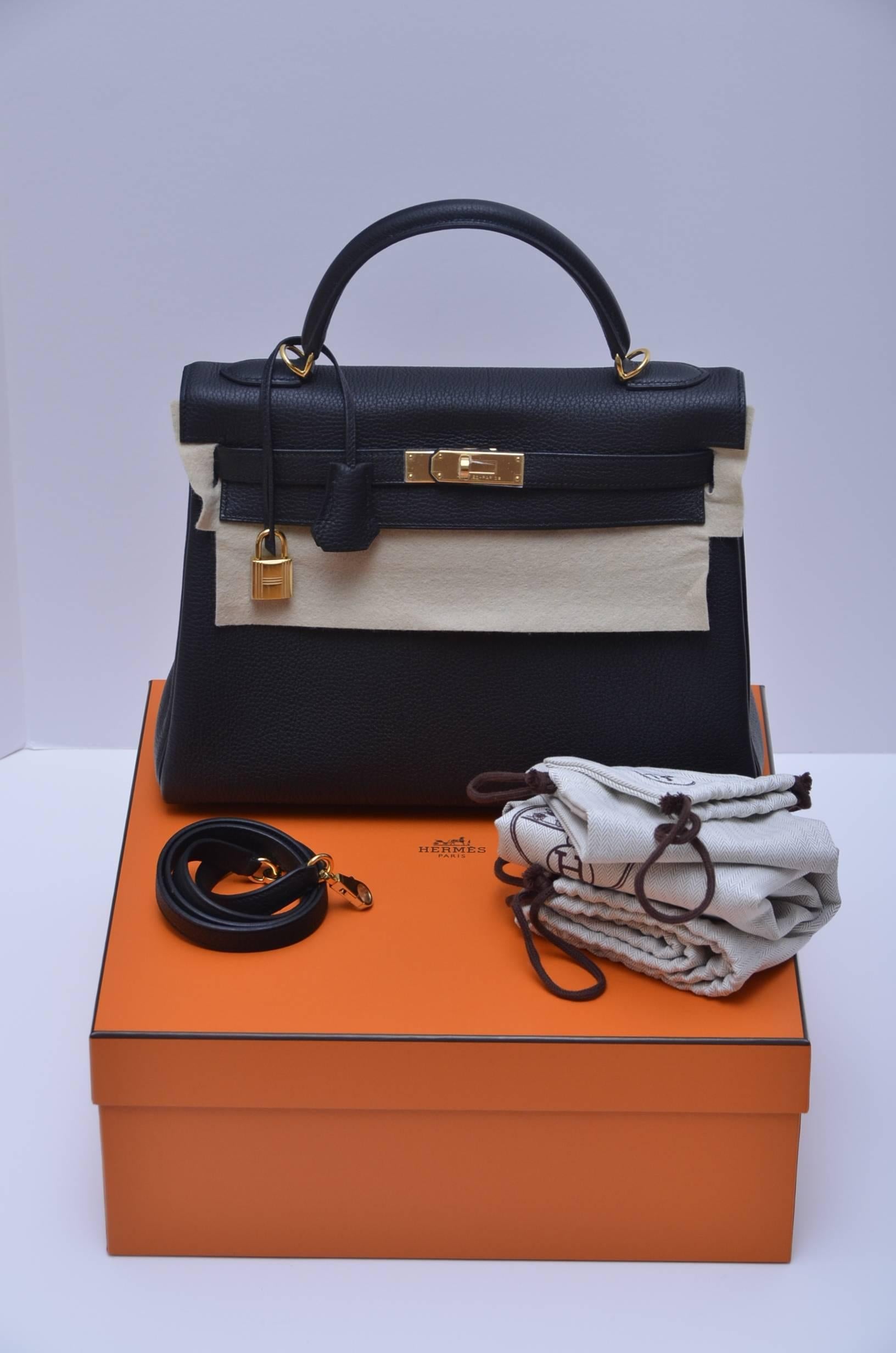 Hermes  Kelly  II Retourne 32cm Jet  Black Veau Togo Gold Hardware.
Included: original box, dustbag, clochette, lock in dust bag , two keys, protective felt, rain coat, clochette dustbag, and care booklet.
Protective plastic on the