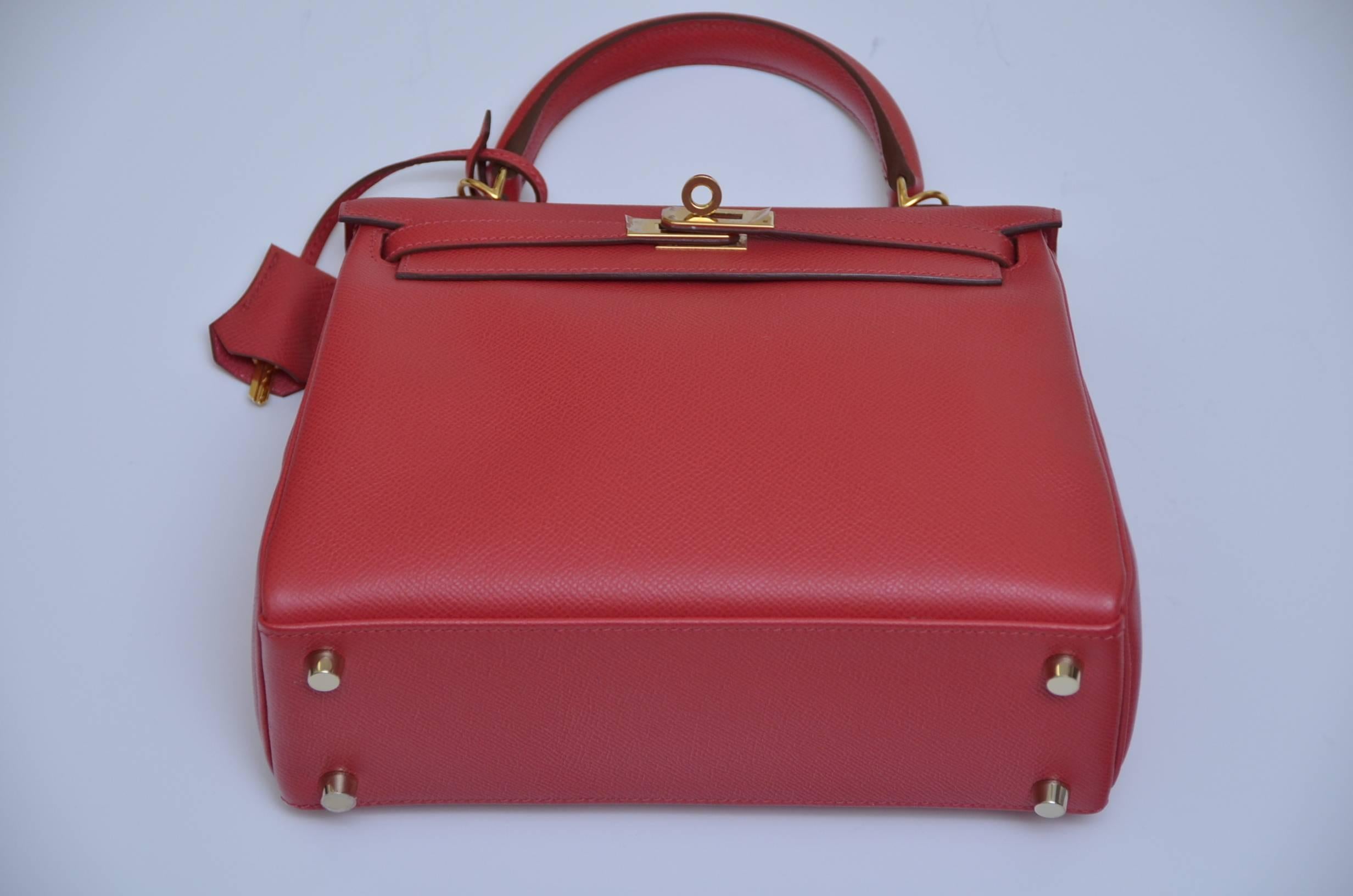 Hermes Kelly Retourne  25 CM with shoulder strap.
Epsom leather .
New with plastic cover on the  the hardware .
Mini kelly with a stiff quality that keeps the bag rigid, Epsom is easy to clean.
Color is rouge.
Color in person might be slightly