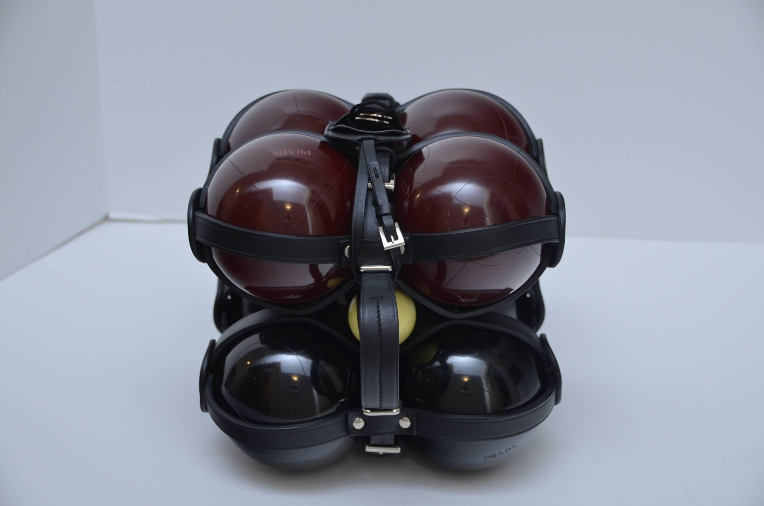 Prada bocce ball set in leather straps.
4 black and 4 maroone balls with PRADA logo embossed on some balls.
Tag and original box included.
Box show little damage from storage but set is brand new.
Very heavy.
Made in Italy.

FINAL SALE.

