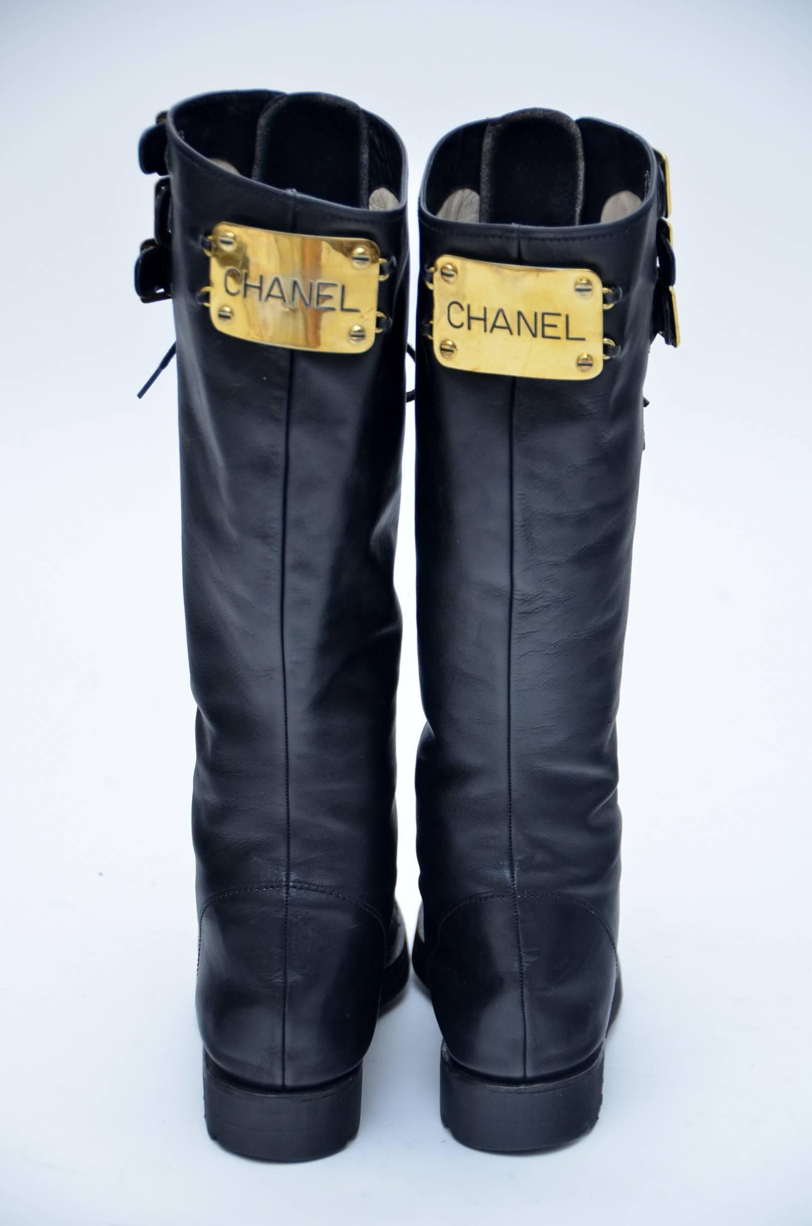 Iconic Chanel combat boots .Imposible to find.These stunning boots have a sturdy rubber base sole with laces the entire length. There are three gold buckles at the top and a gold plaque behind with the cut-out Chanel name logo. The toes each have a