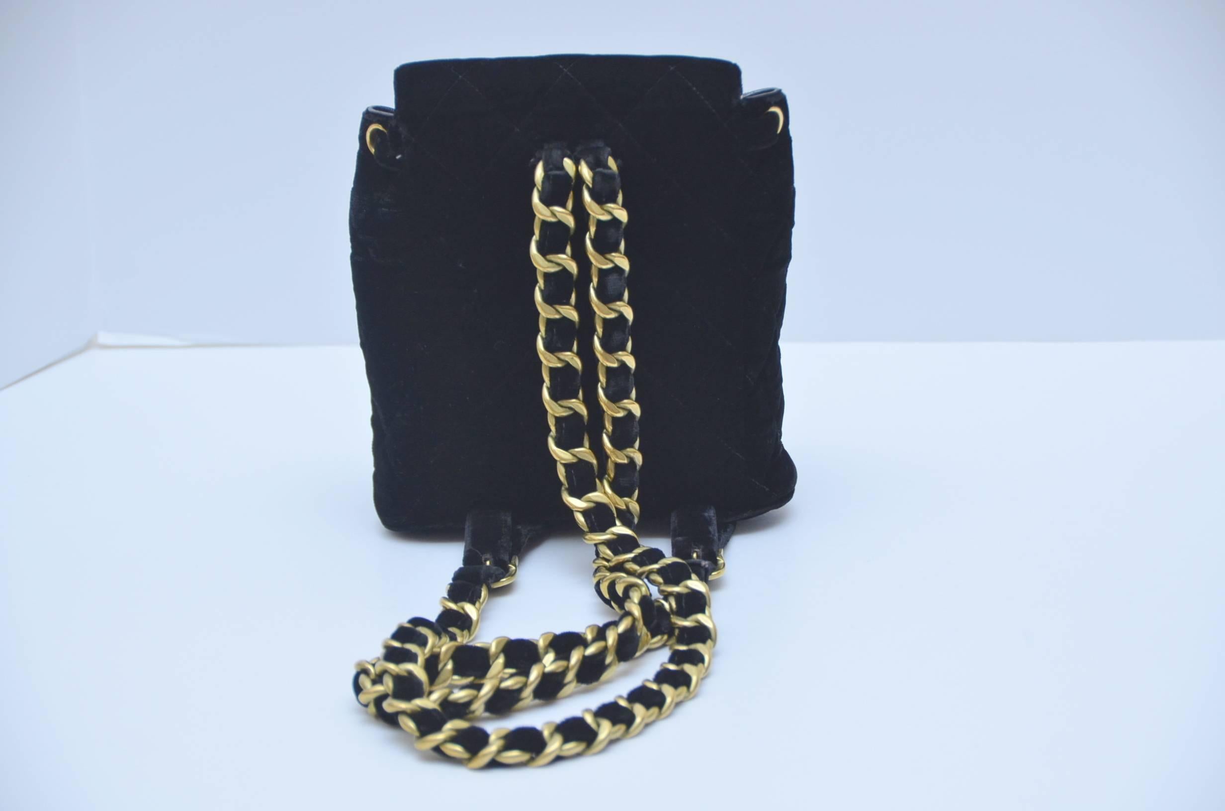 Chanel quilted black velvet, and  leather lined mini back pack from 1990's.
Double shoulder straps have gold chain and adjustable buckles.Upper flap opens to the main compartment and is lined in black leather.
The lower outside flap opens to a