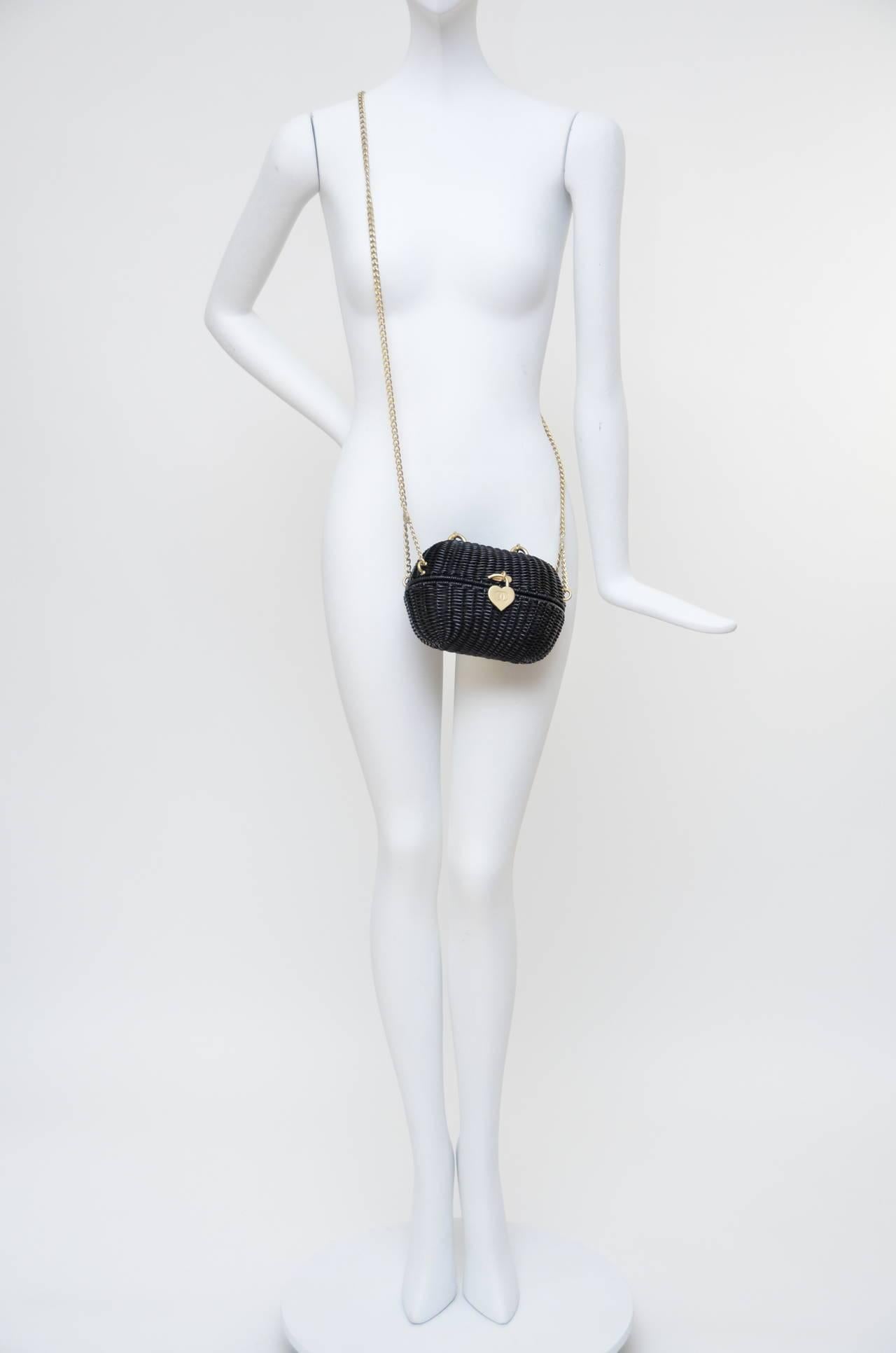 Excellent like new Chanel black mini straw handbag.
This Highly Collectible Authentic Chanel Sweetheart  black handbag was designed in 2005.it is called the Divers Sac. It is a straw woven wicker basket with a heart shaped closure. All the hardware