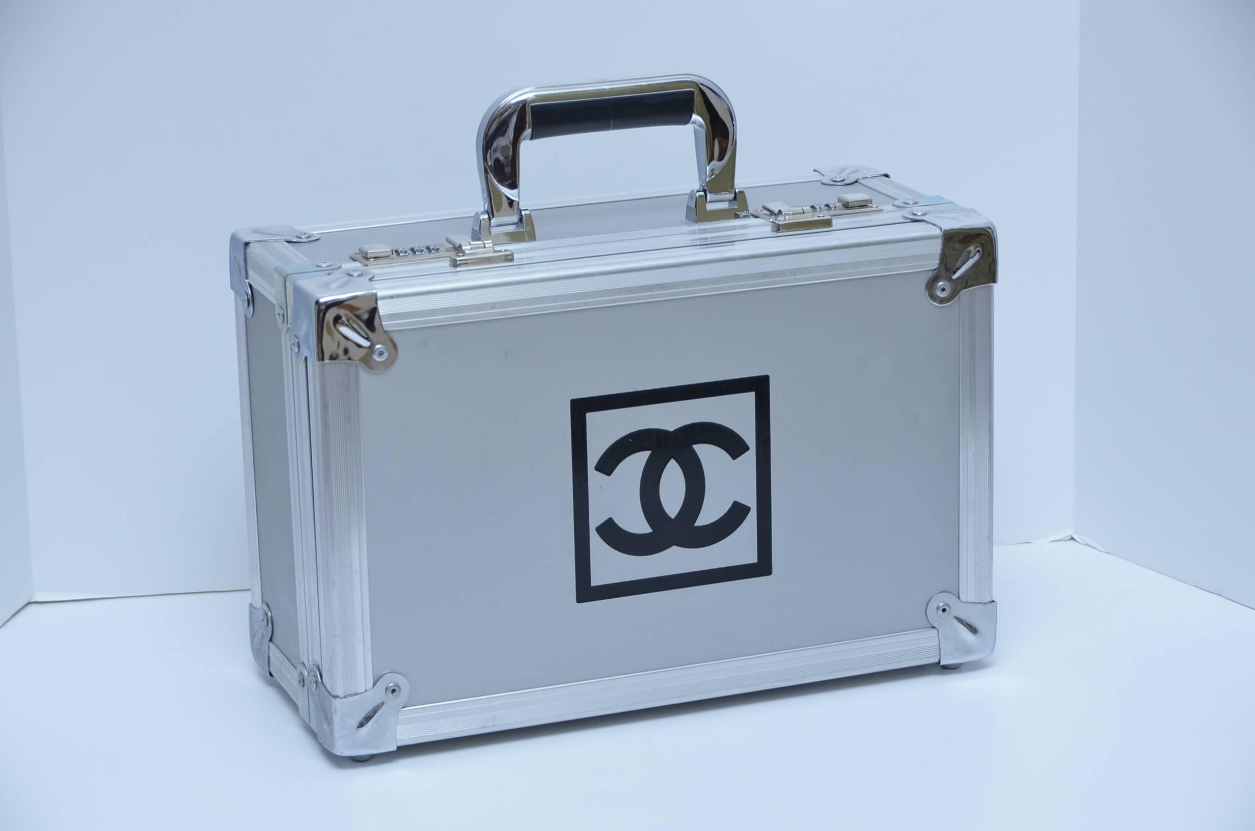 Chanel has created a stylish metal bocce ball  Pétanque set. 
The Italian  bocce ball set includes six stainless steel balls engraved with Chanel and a wooden jack, which is the target in the game.
Silver tone metal box with 3  zero  digit combo