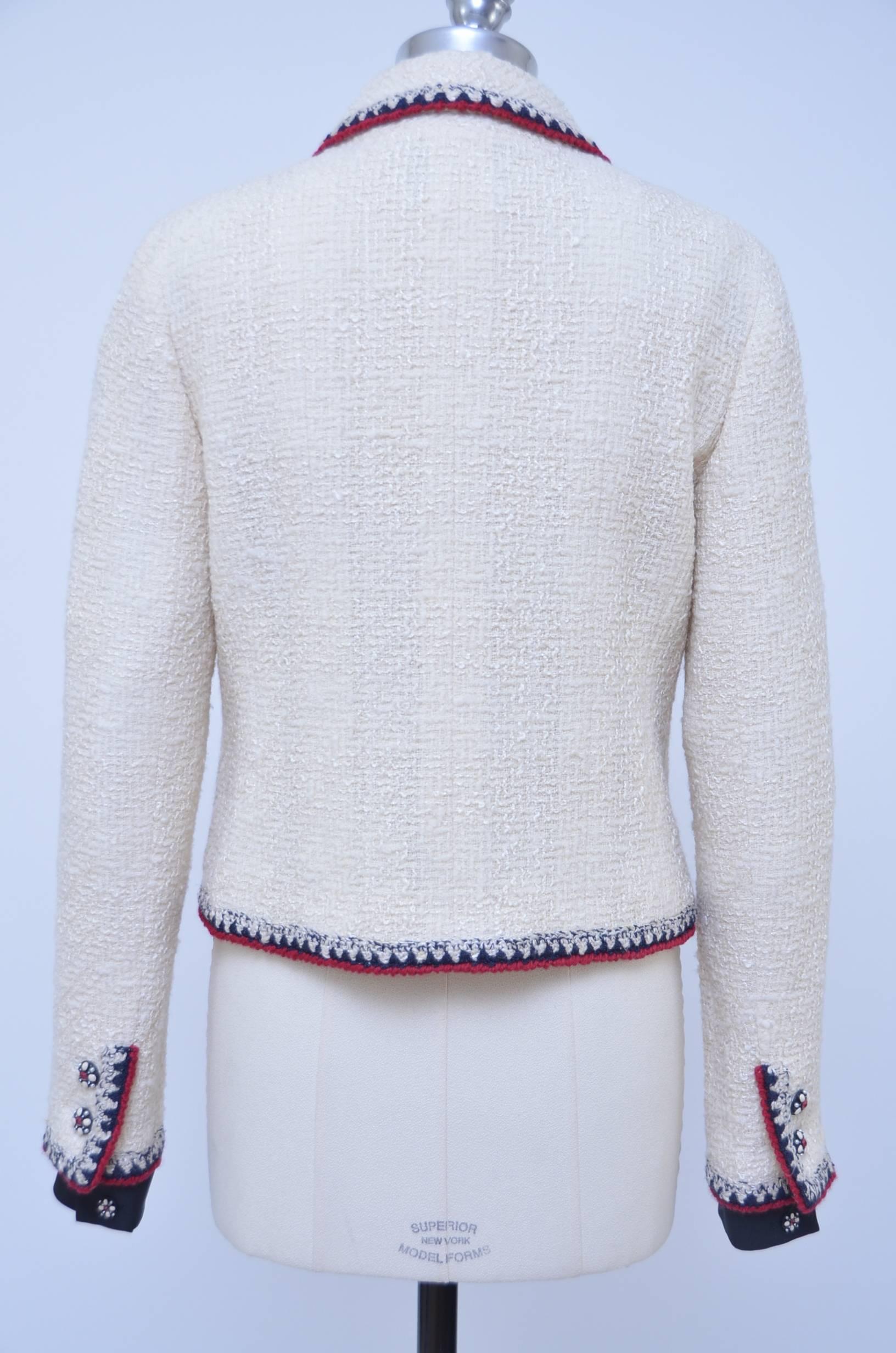 Iconic and collectible 2006 Chanel boucle jacket.
Beautiful ecru color boucle fabric.
4 flap pockets in the front with button closure.Each sleeve has 2 buttons  with extra button on the removable cuff.Cuff is silk very dark blue color.
Cream silk
