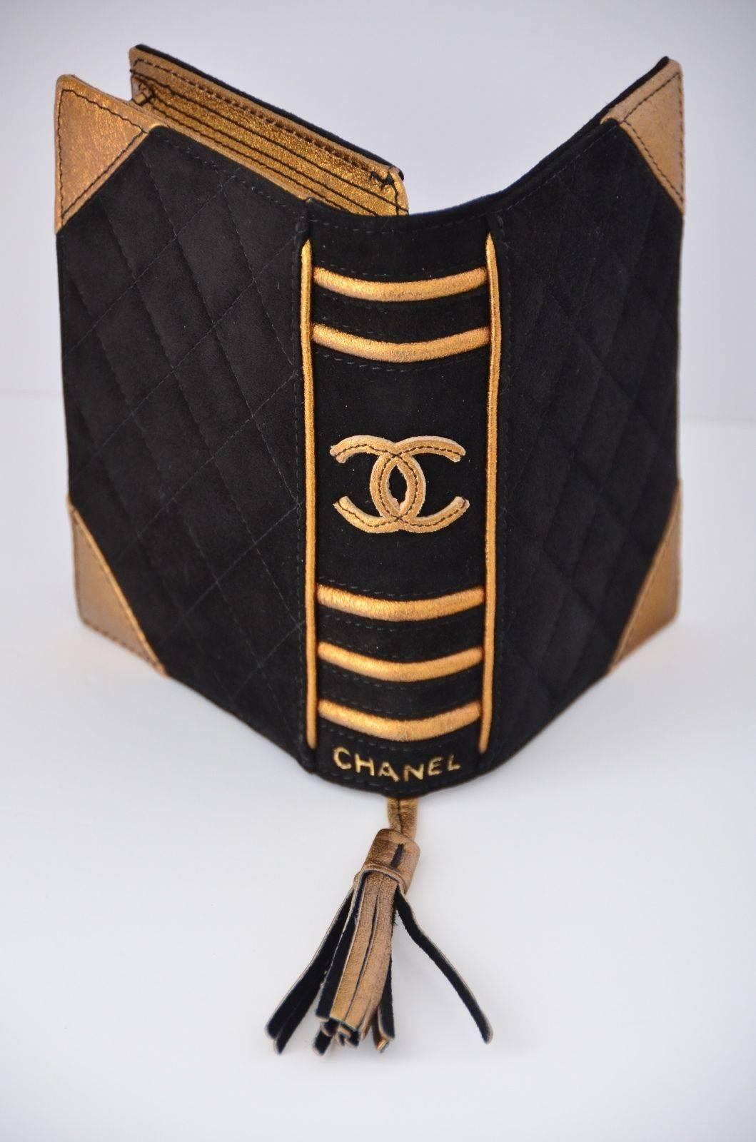CHANEL BIBLE CLUTCH BOOK SUEDE LEATHER COLLECTOR'S ITEM LIMITED EDITION 2003

Black/gold suede quilted 'bible' clutch. Black suede leather with bronze metallic color details. Front flap with hidden magnetic closure. Golden leather tassel.