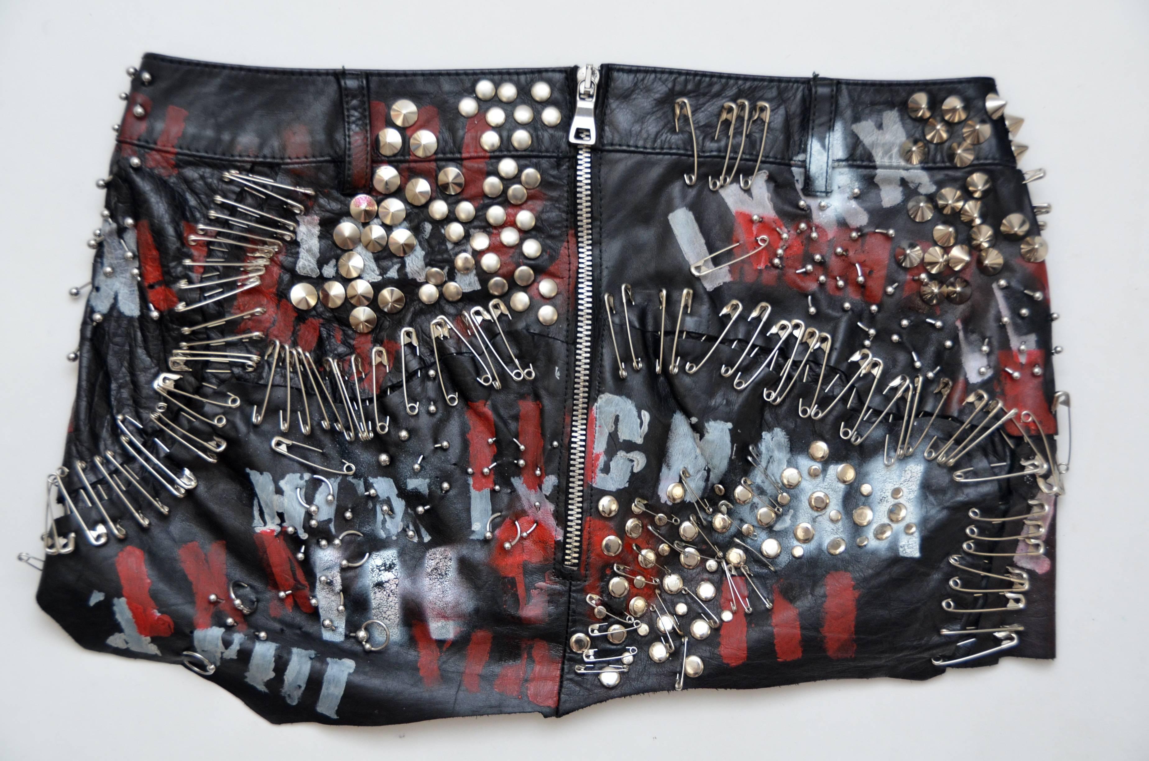 Balmain runway 2011 leather safety pin studded embellished skirt.
Excellent pre-owned collection.Style of the skirt is kind of destructed with lot's of safety pins and different studs with red/white graffiti  words painted and few little