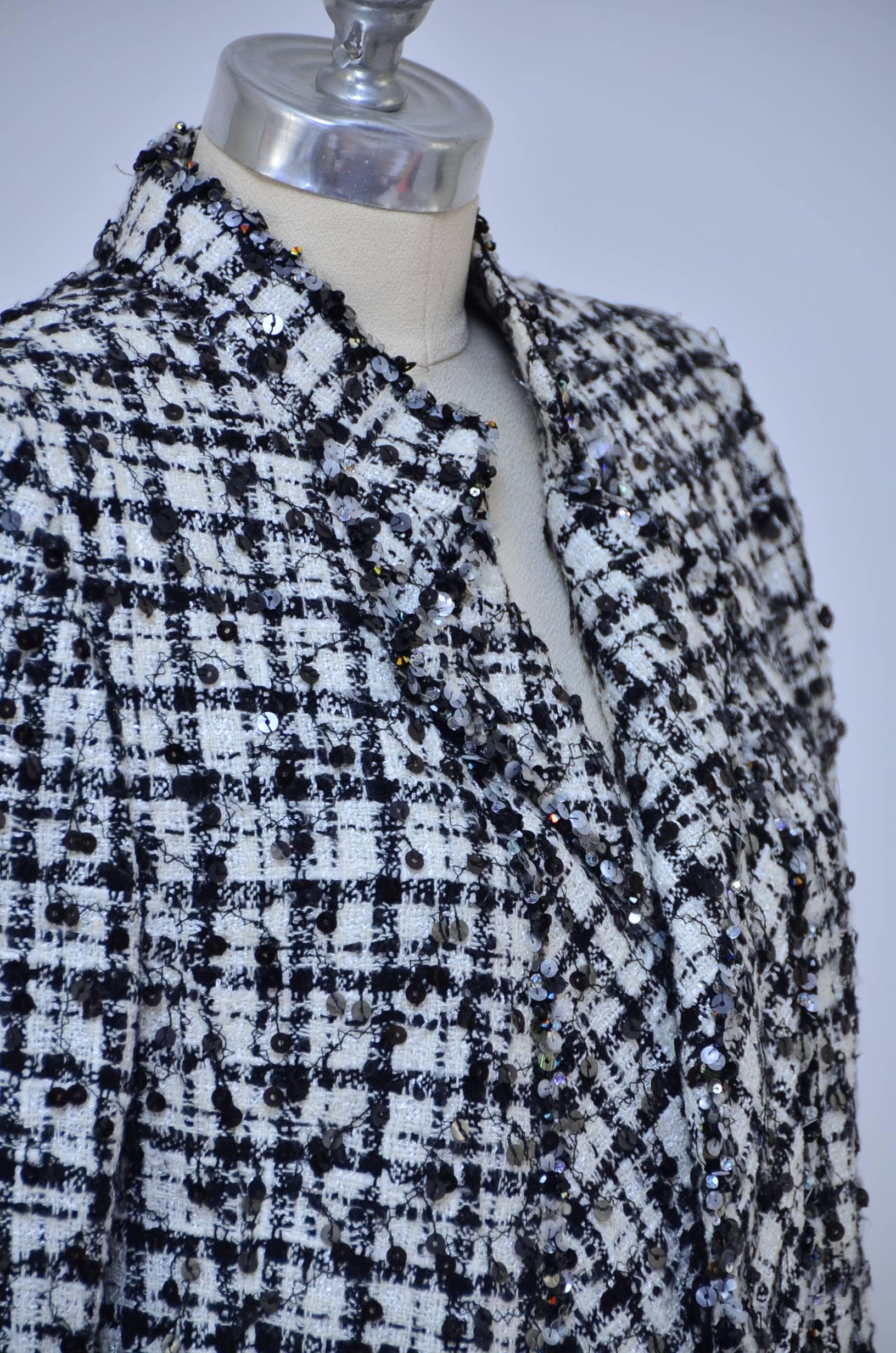 Beautiful Chanel Haute Couture black/white tweed suit.
Embellished with black sequence and beads.
Jacket with matching skirt.Jacket has mini folded collar and no buttons in the front.Open front.
Approximate measure:
Jacket waist 40