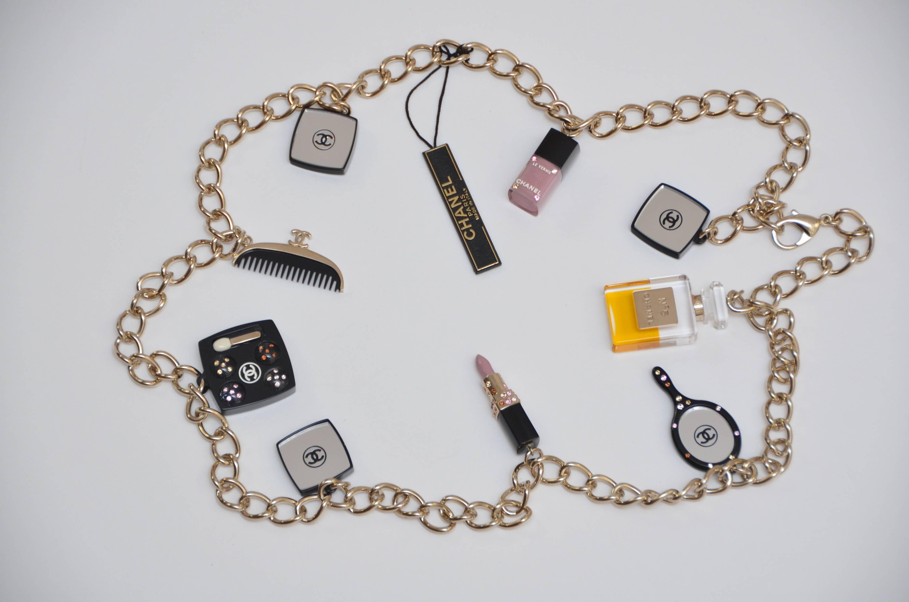 Very rare Chanel makeup necklace from 2008 collection.
Beautiful charm necklace featuring 9 make up charms as ...nail polish,mirror,eyeshadow compact,Chanel 5 perfume bottle,comb.....
Chain is light gold tone color (something between gold/silver