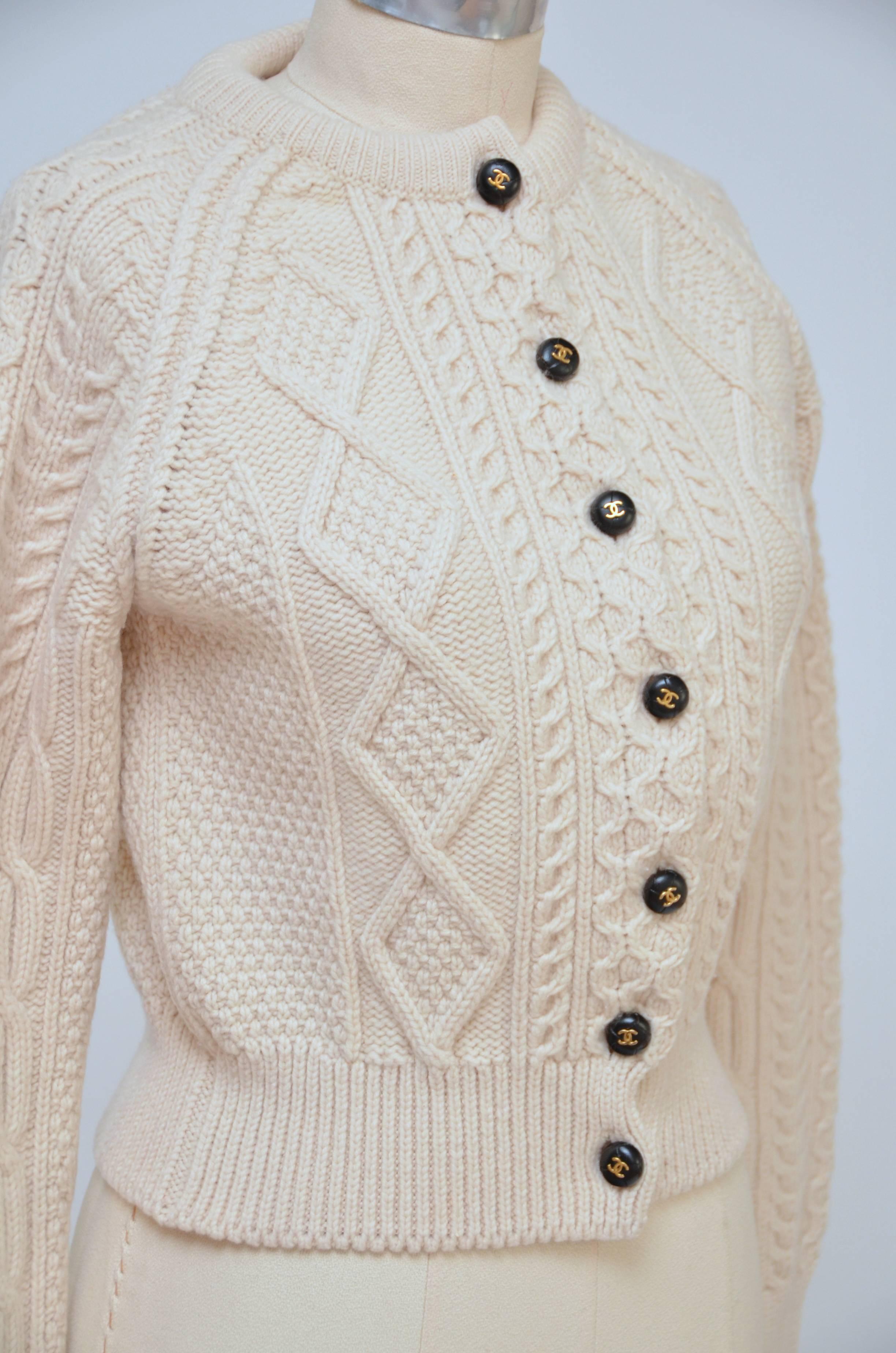 Cream Chanel wool cardigan with crew neck, long sleeves, cable knit stitching and button closures at front. 
From the Pre-Fall 1996 Collection. Fabric: 100% Wool
Measurements: Bust 36