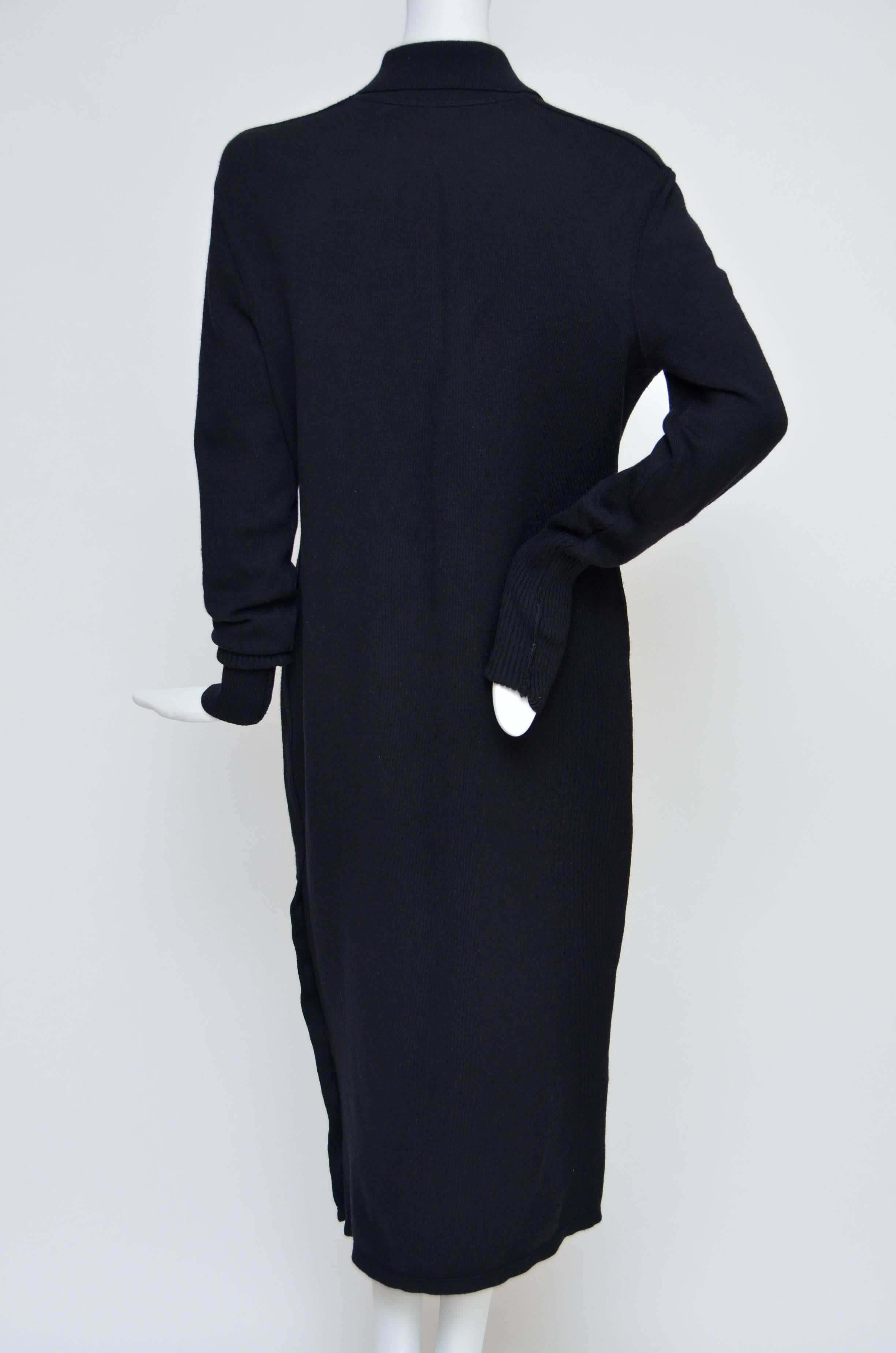 Robe noire vintage de Chanel en excellent état.
Gros boutons CC sur le devant et les côtés.
Très belle robe, tissu épais. 
Les tissus ne présentent ni trous ni décoloration.
Les manches sont bordées de côtes et peuvent être repliées. Photographié