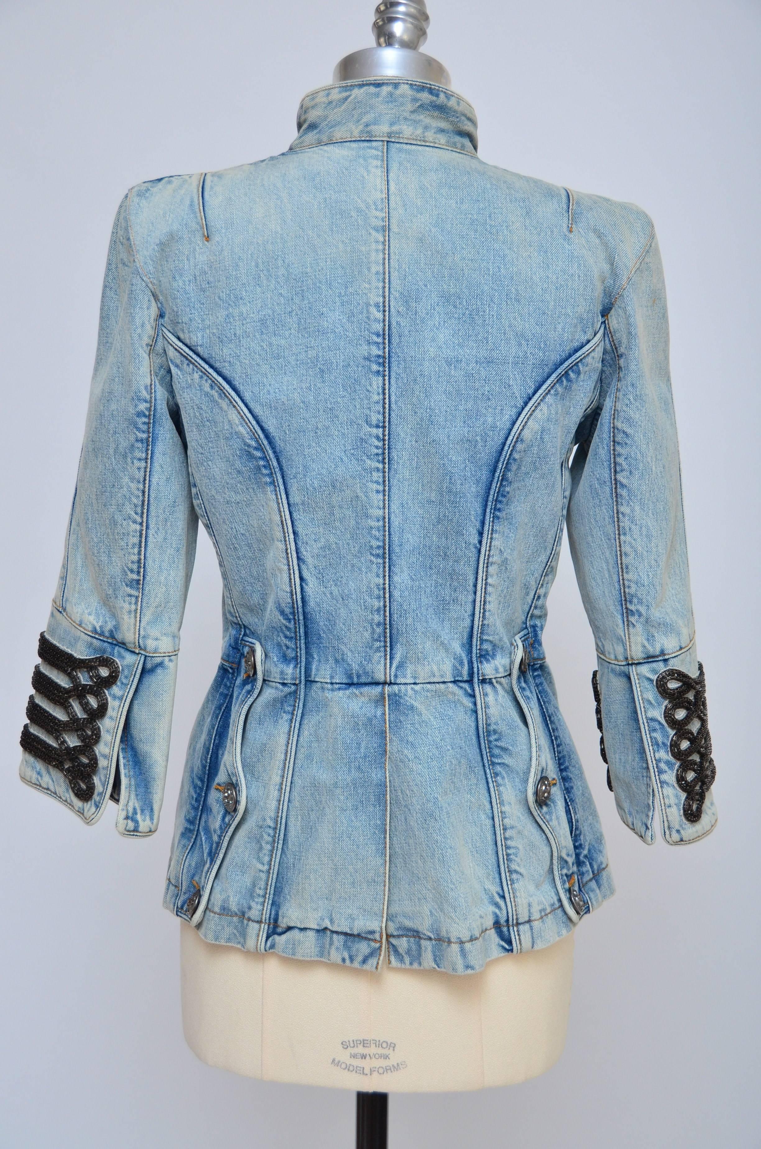 Double breasted denim jacket with military detail. Jacket has three-quarter length sleeves, padded shoulders, is unlined and fastens on front with buttons at side. 100% cotton. Dry clean. 
Excellent condition.
Please note:Shoulder pads had been