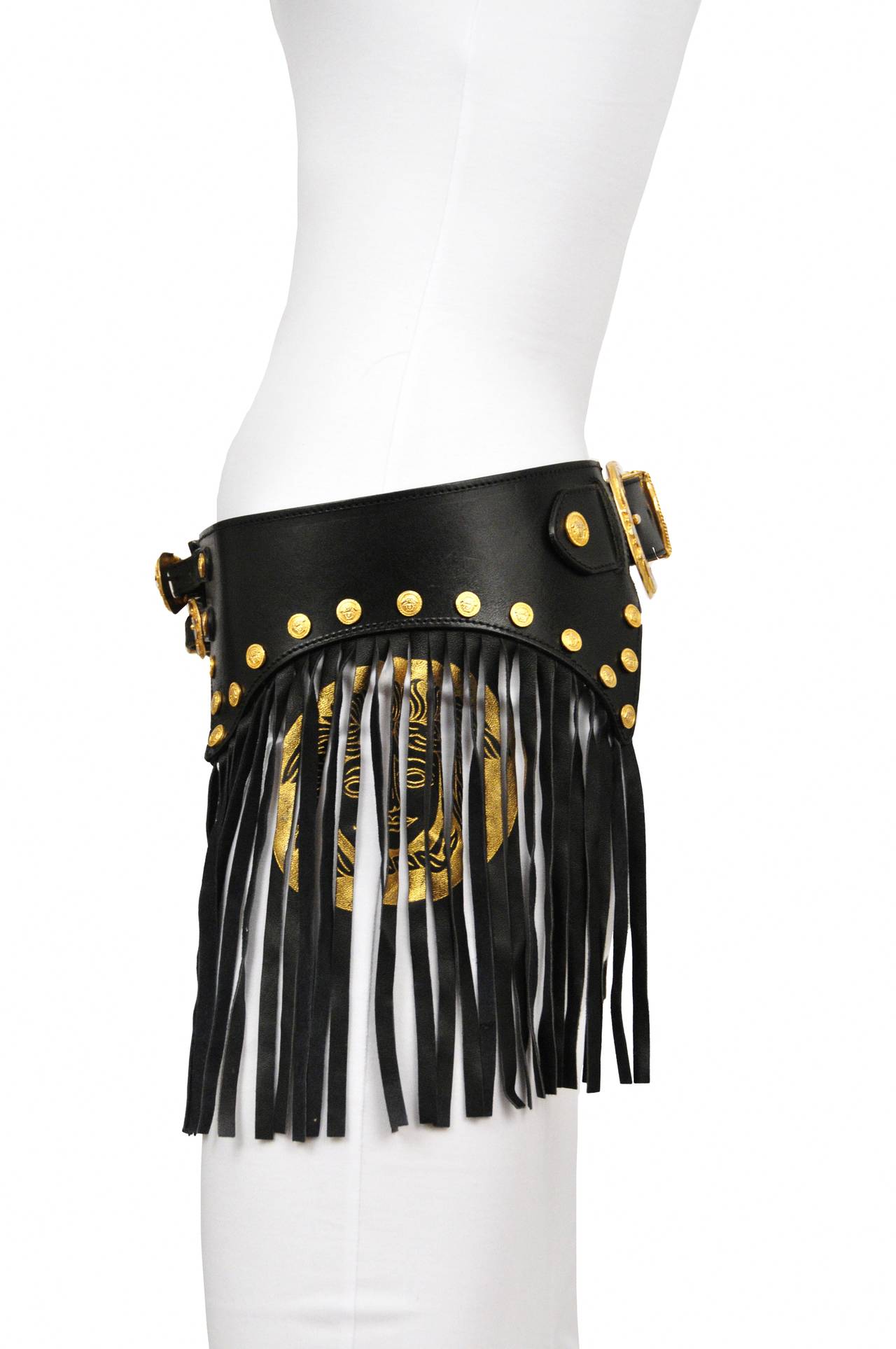 Vintage Gianni Versace black leather bondage belt with gold buckle detail and medusa emblem printed on fringe.