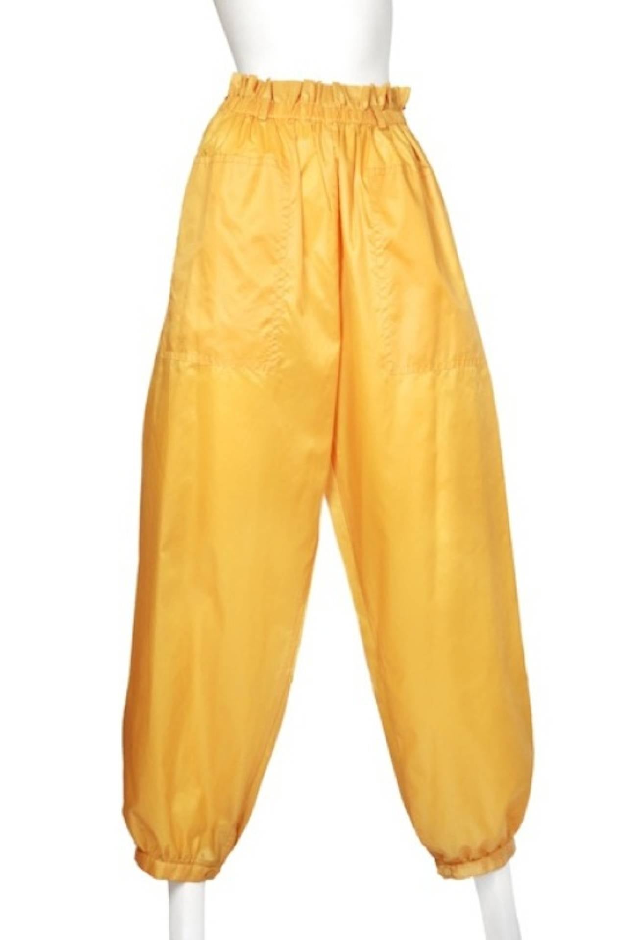 Vintage Issey Miyake classic rain slicker yellow two piece rain ensemble. 
The jacket has an open cape style body and adjustable cuffs and snap closure at neck. The pants have elastic waistband and patch pockets.