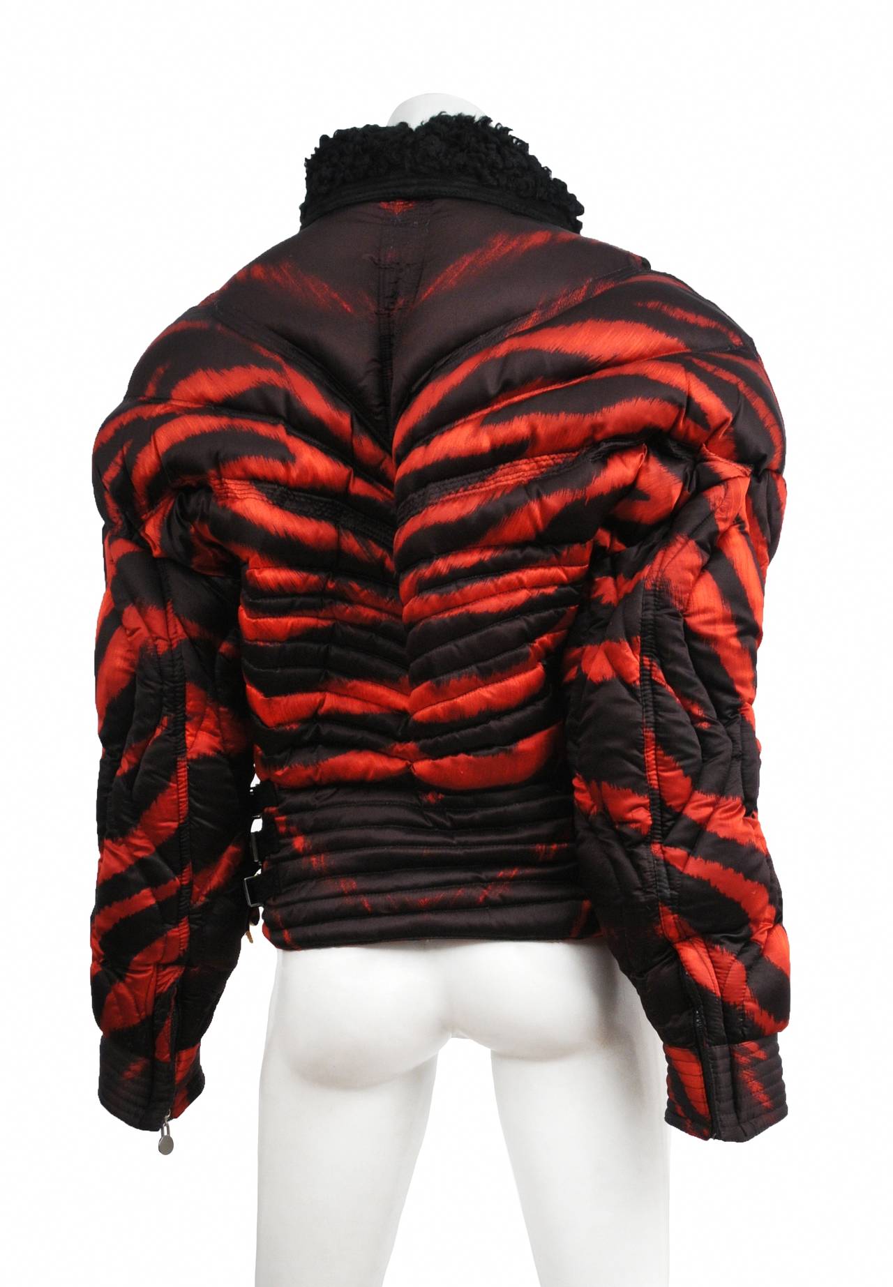Gianni Versace rare apres quilted ski jacket with red and black tiger print. Corset style waist has leather and gold bondage buckles. The zipper pulls through out are adorned with the medusa icon. Jacket is trimmed in black suede with mongolian fur