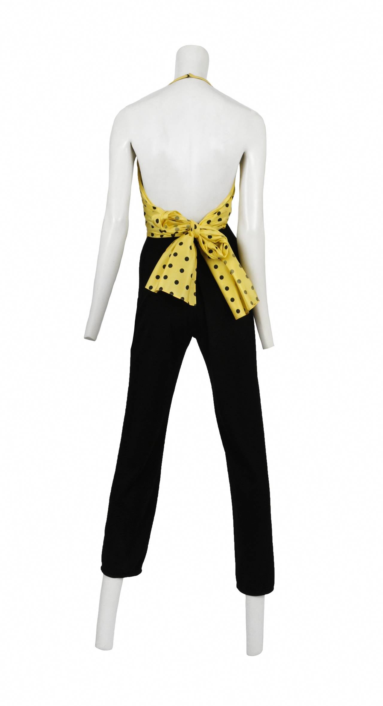 Vintage Geoffrey Beene jumpsuit featuring a yellow and black polka dot silk halter blouse attached to black trousers with a bow tie in back.