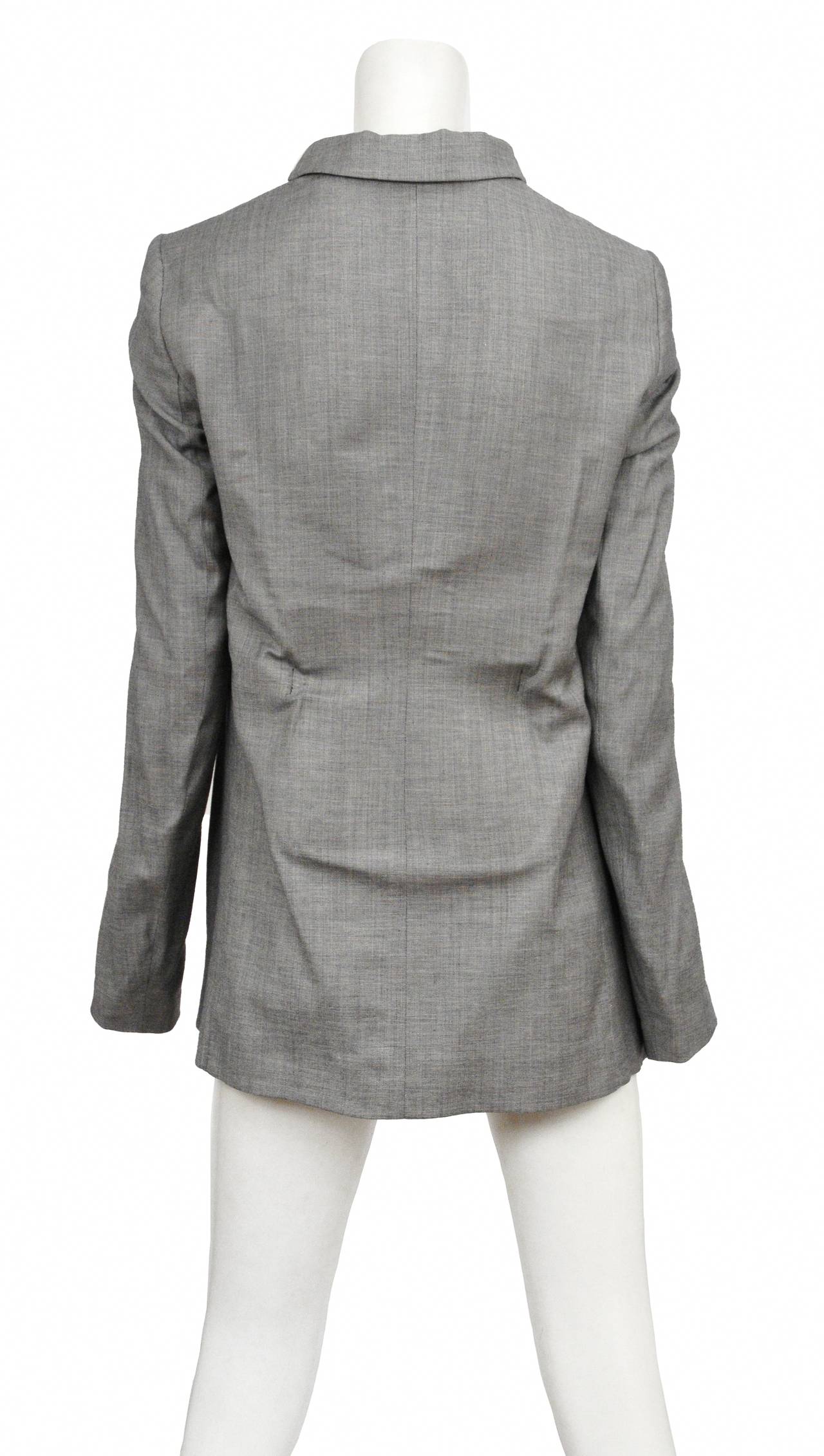 Vintage Maison Martin Margiela grey blazer featuring a structured back with a plate like piece beneath the fabric. The jacket has lightly padded nude colored shoulders, a built in waist belt and soft lining.