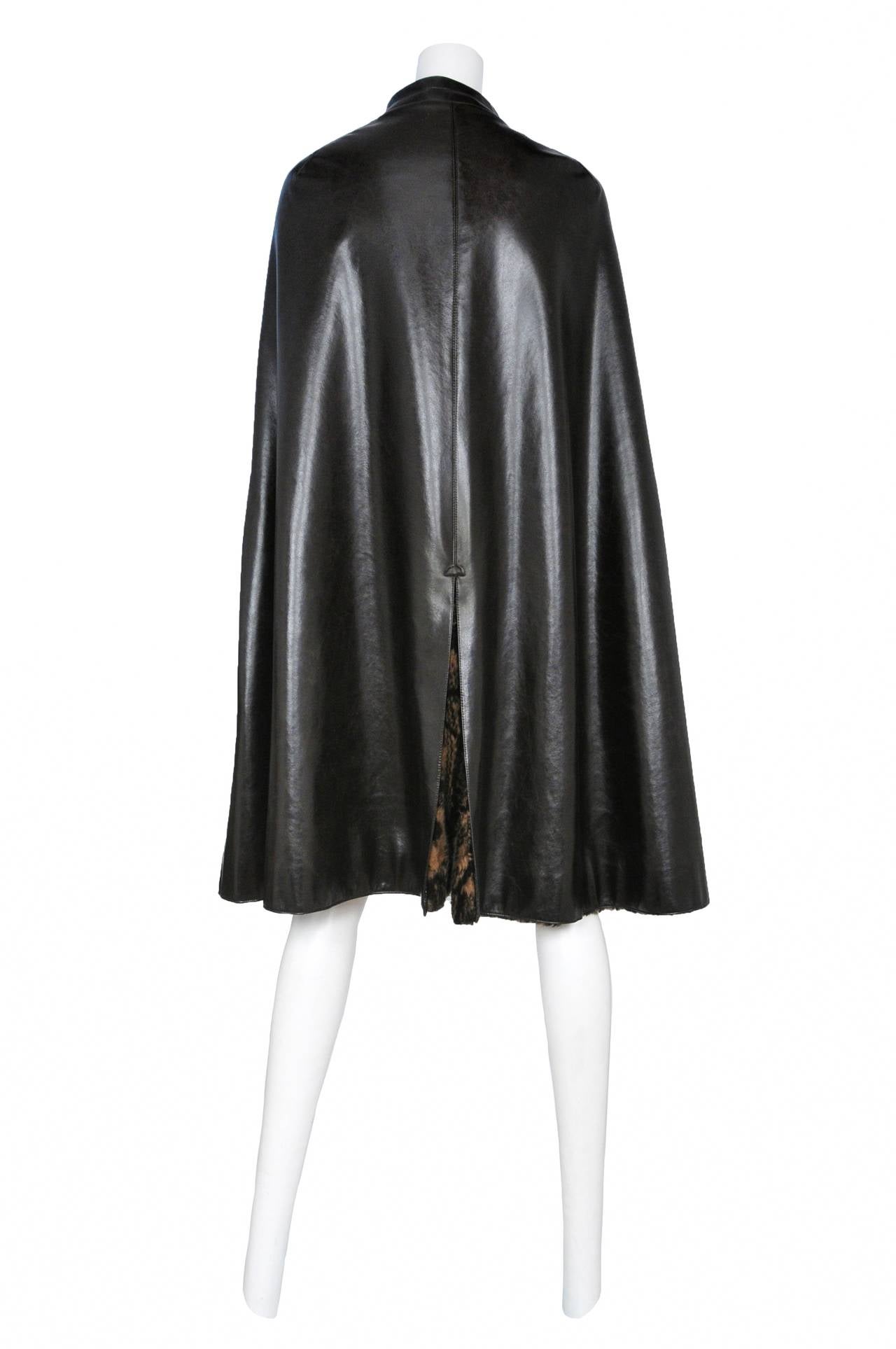 Vintage Pierre Cardin dark brown vinyl zip front cape with two circle patch pockets featuring horizontal stitching and faux fur lining.