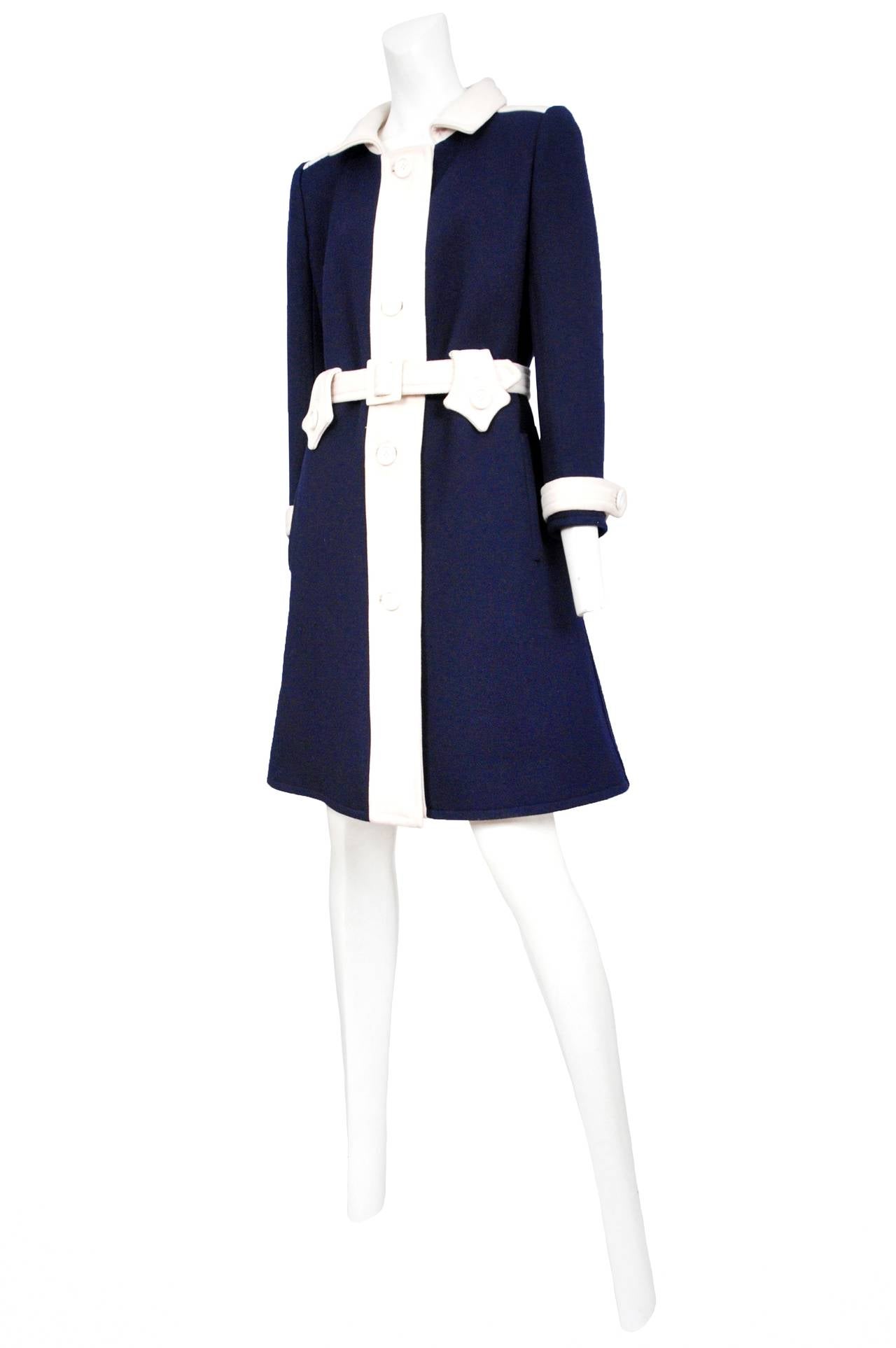 Vintage Andre Courreges navy wool mid length coat featuring a white button placket, buttons, cuff details, collar and matching belt.