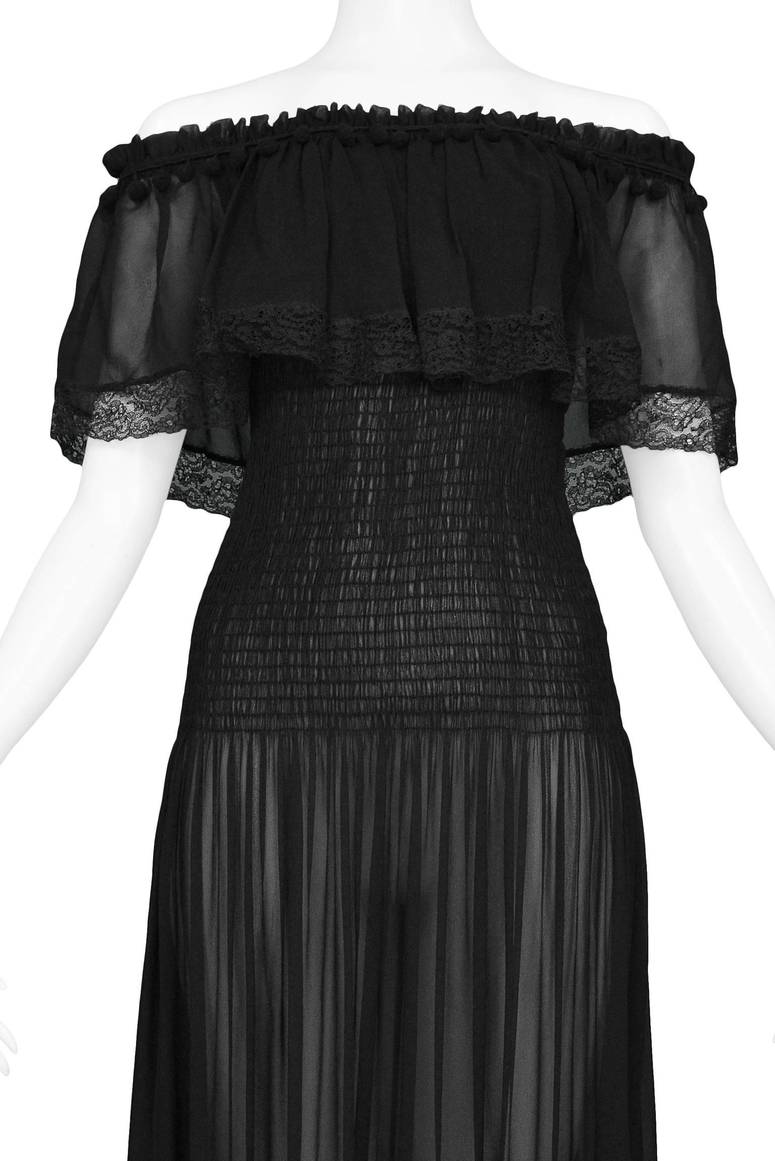 Vintage Yves Saint Laurent black silk chiffon peasant dress featuring pom pom trimmed elastic gathering at the top to keep it suspended off the shoulders.  The semi sheer dress is adorned with black lace trim at the hems and smocking at the middle