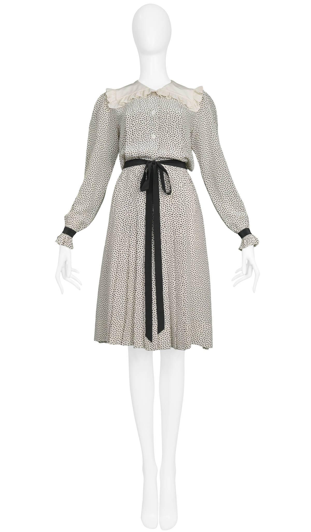 Vintage Yves Saint Laurent silk ivory pleated day dress with allover dot print, ruffle collar, and ribbon tie at waist and wrists. Circa 1970s. 

Excellent Condition.

Size: FR 34
