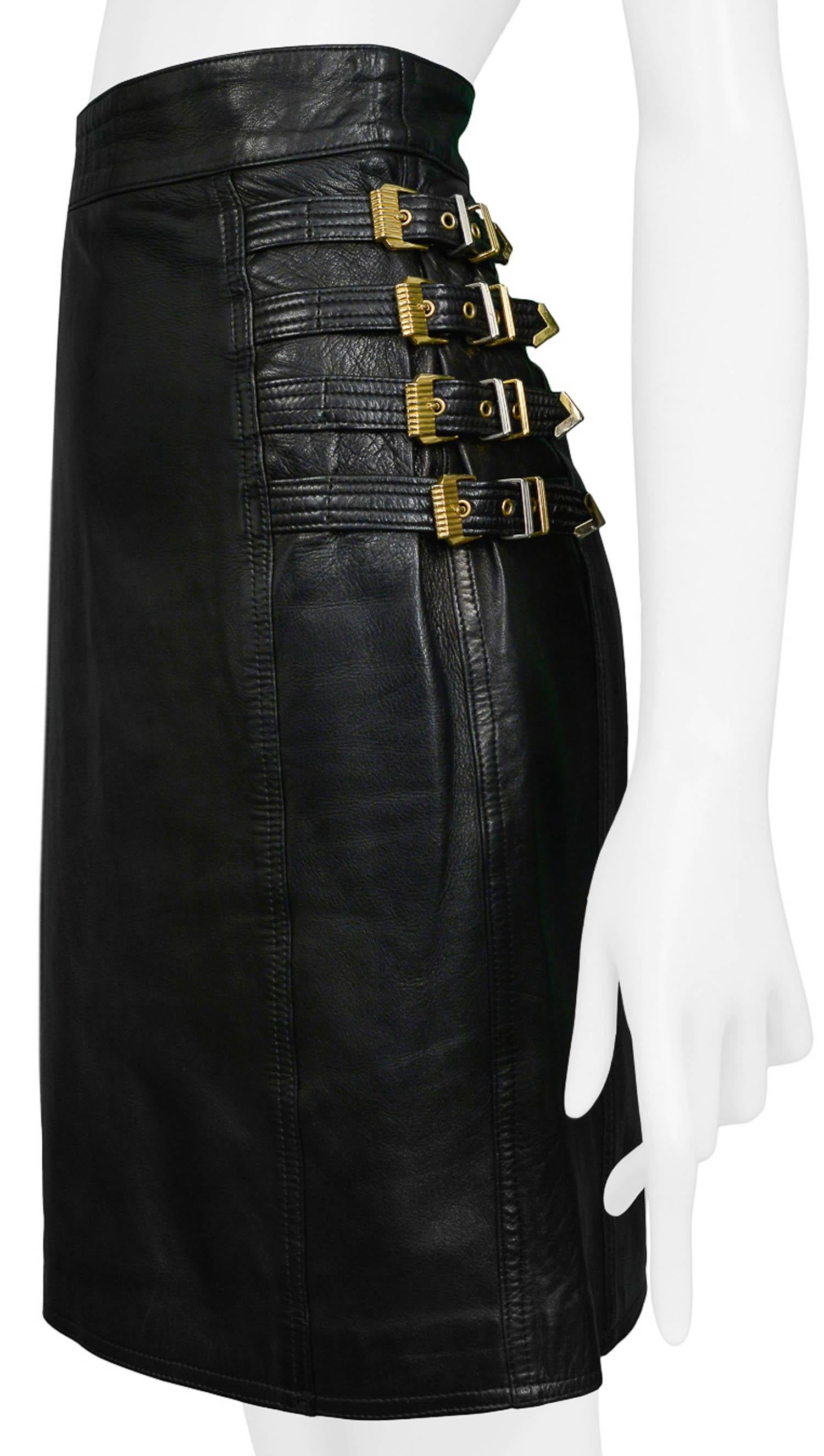 Vintage Gianni Versace black leather bondage fitted skirt with gold and silver tone buckles at hips. From the Autumn/Winter 1992 Collection. 

Excellent Condition.

Size: 42