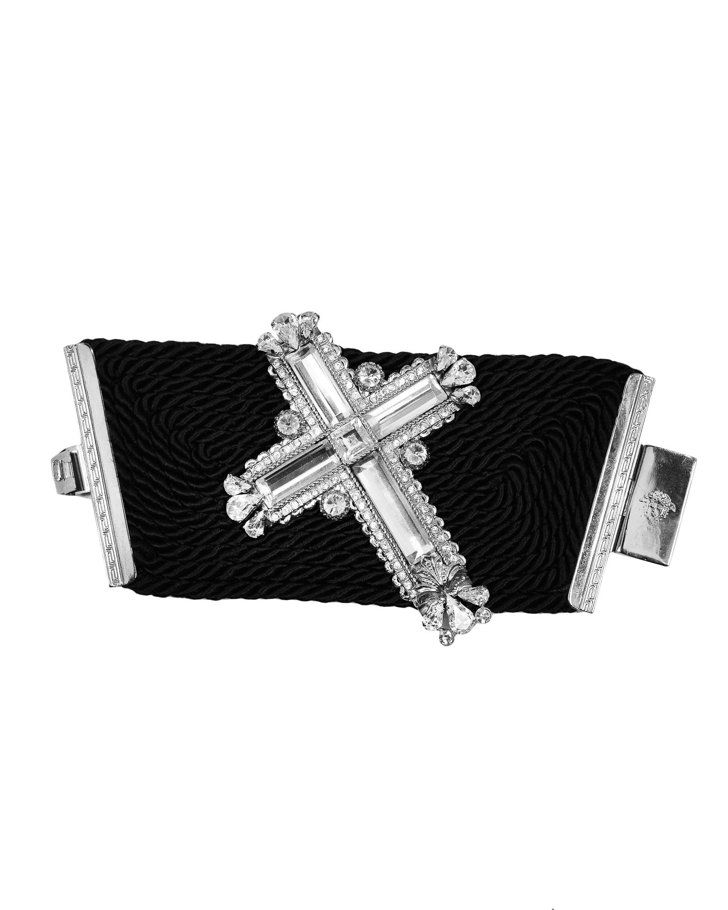 Vintage Gianni Versace black silk cord bracelet with large rhinestone embellished silver-tone cross with slide clasp closure. Circa 1990's. 

Excellent Condition.