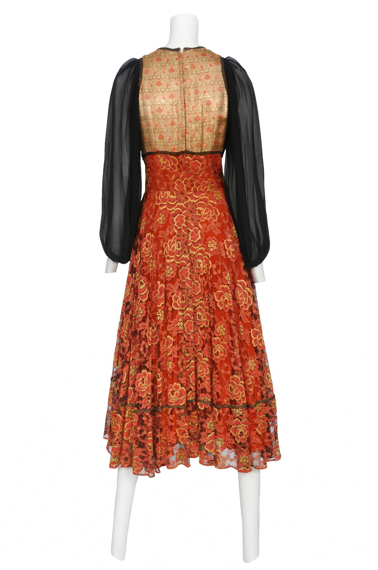 Vintage Thea Porter empire bohemian dress with a gold and coral jacquard bust edged with gold braided trim attached to a red and gold floral black lace skirt and finished off with black silk chiffon peasant sleeves.