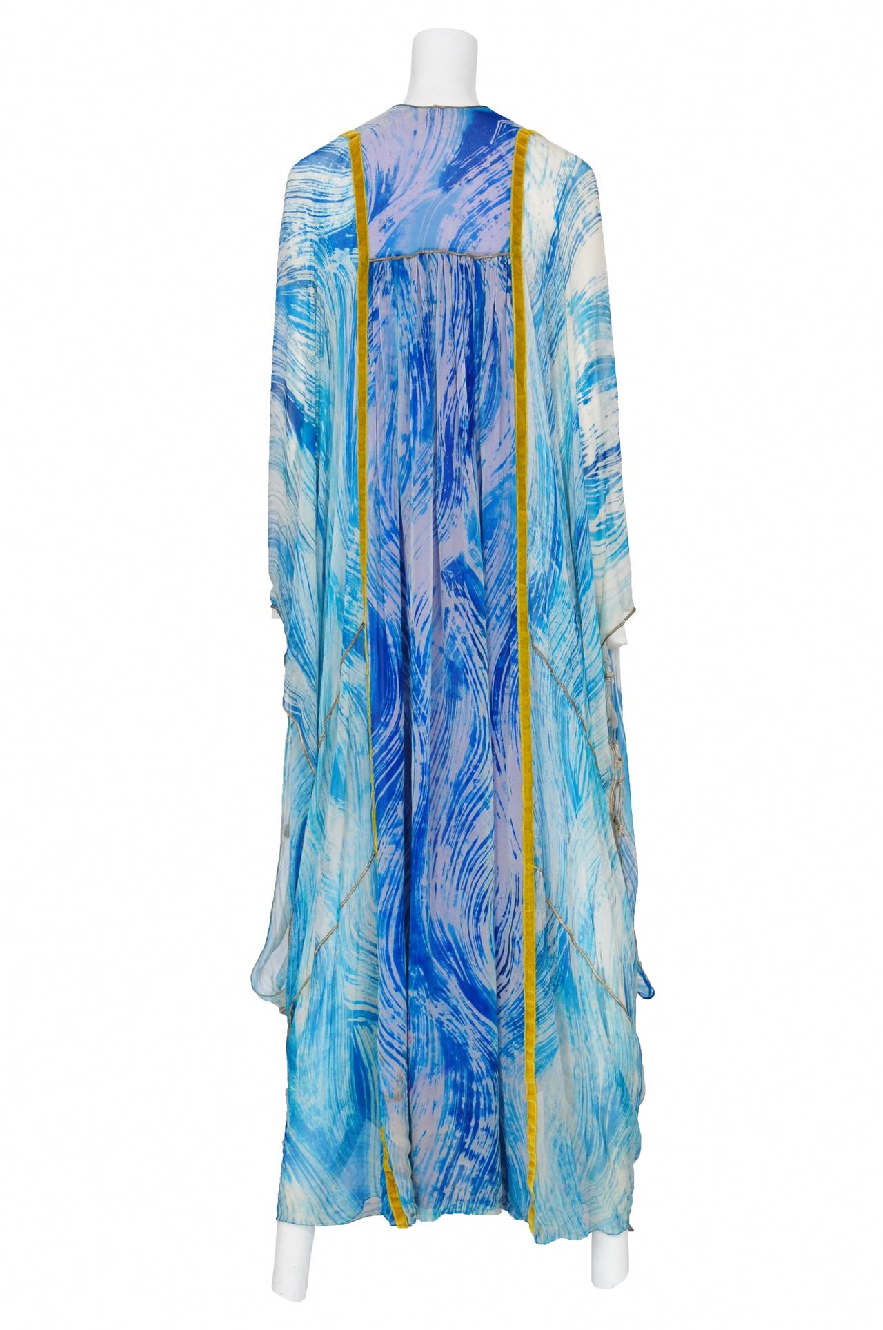 Vintage Thea Porter blue brush stroke print chiffon caftan featuring blue sequin detail at the yoke as well as various patchwork throughout accompanied with gold piping throughout patchwork and along sleeve edges.
Please inquire for additional