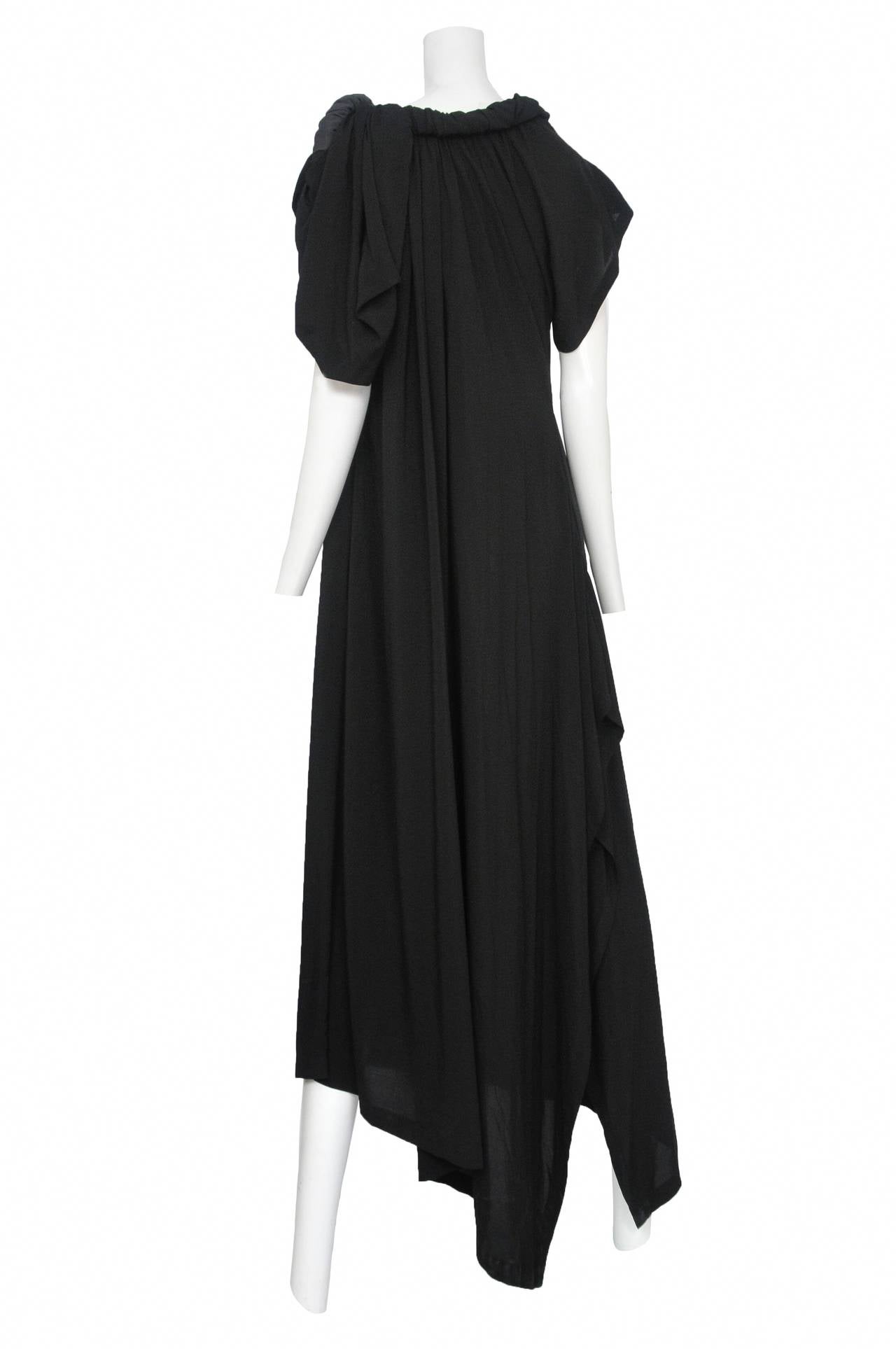 Vintage Yohji Yamamoto black long rayon short sleeve asymmetrical dress with one side pocket and features an adjustable silk and rayon covered tube that follows the neckline.