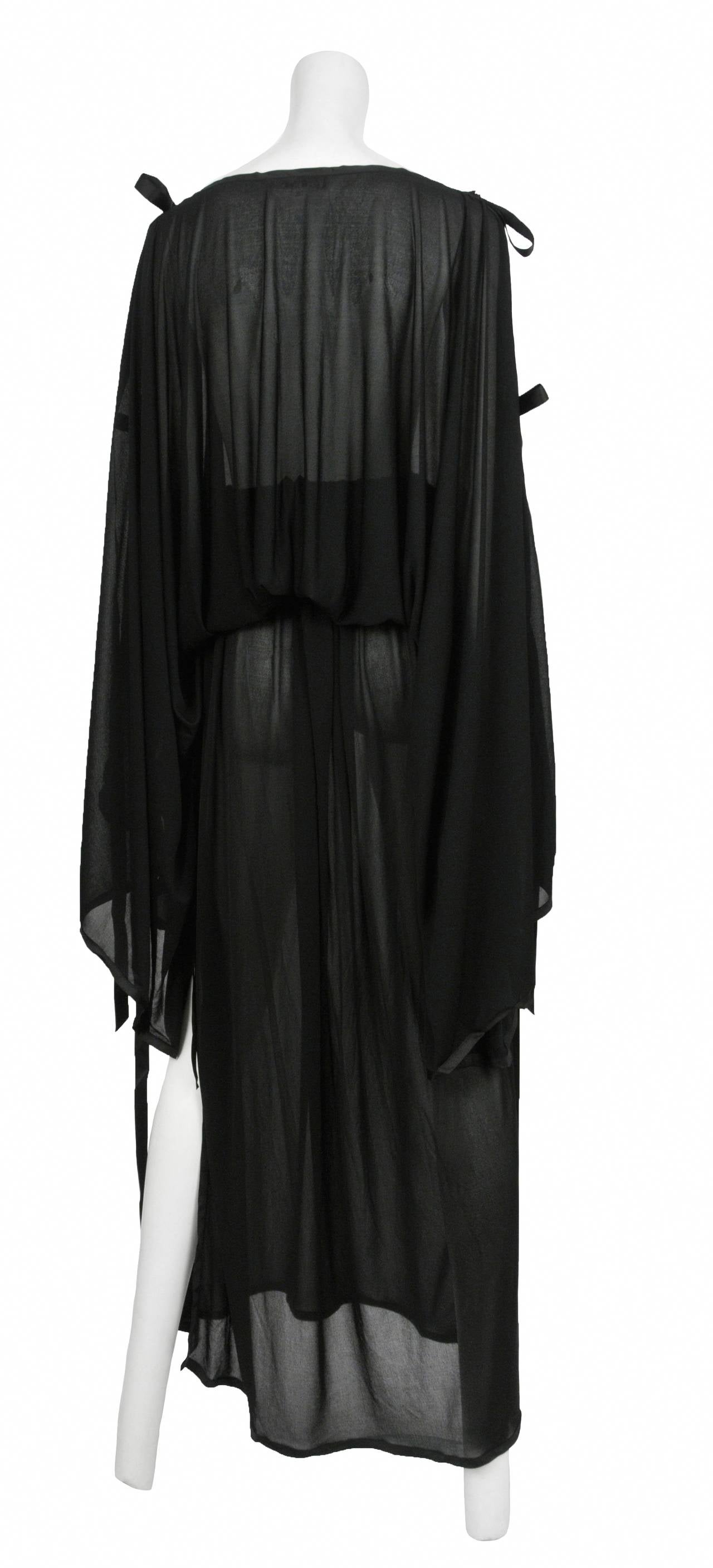 Vintage Yves Saint Laurent YSL black sheer very fine jersey kimono sleeve two piece ensemble. The top has large kimono style sleeves with black satin ribbon closure and gathered waist. The skirt has a shirrred waistband with straight skirt, side