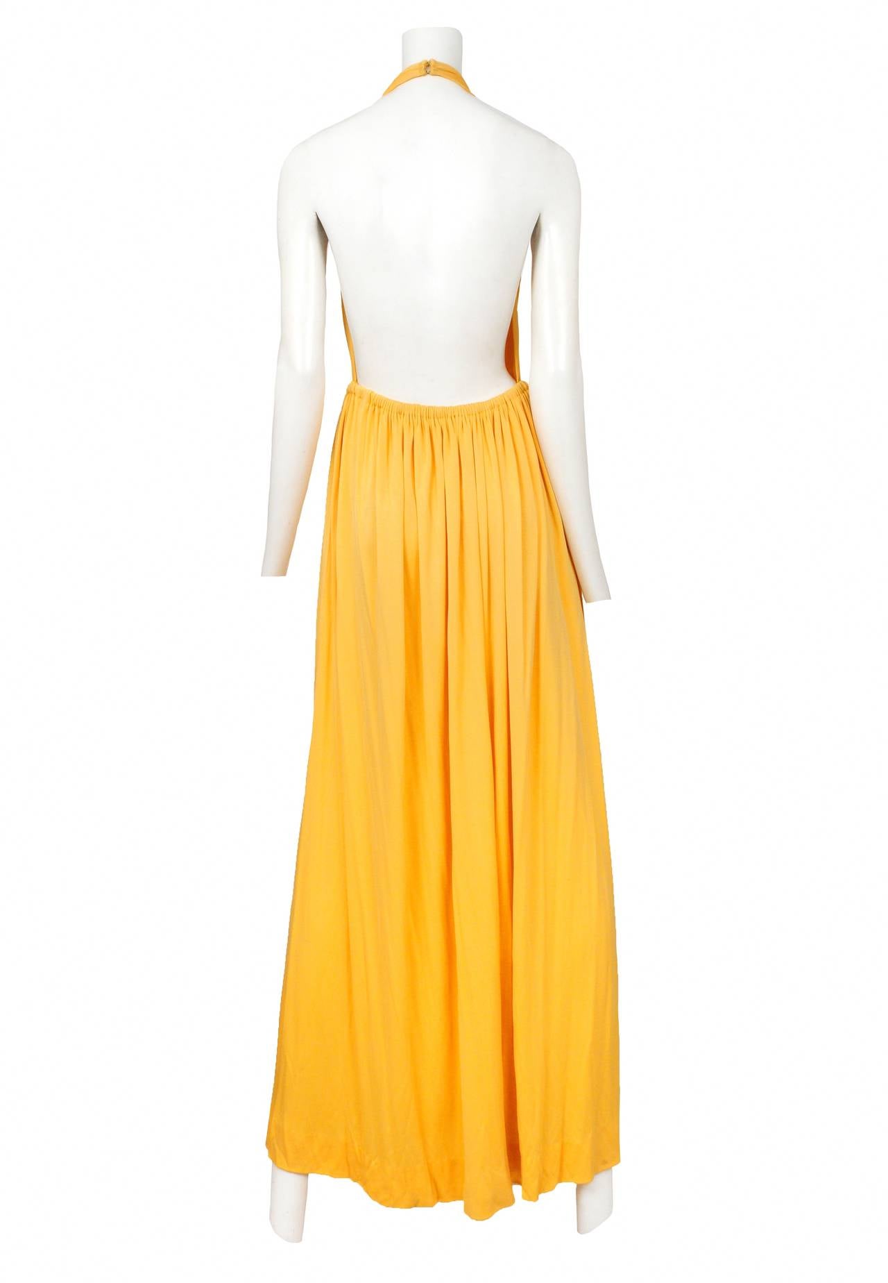 Vintage Halston marigold halter gown featuring an open back and gathered wrap waist line.