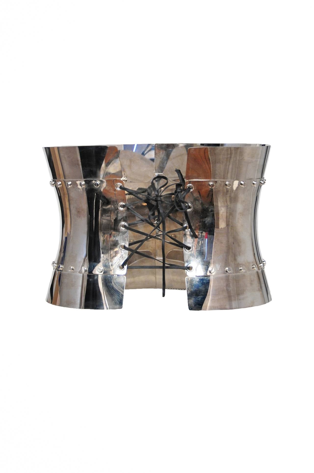 Vintage Dolce & Gabbana chrome metal corset featuring 2 locks at the front with attached key, and a lace up back. Circa 2007.

Waist Measures and 25- 30