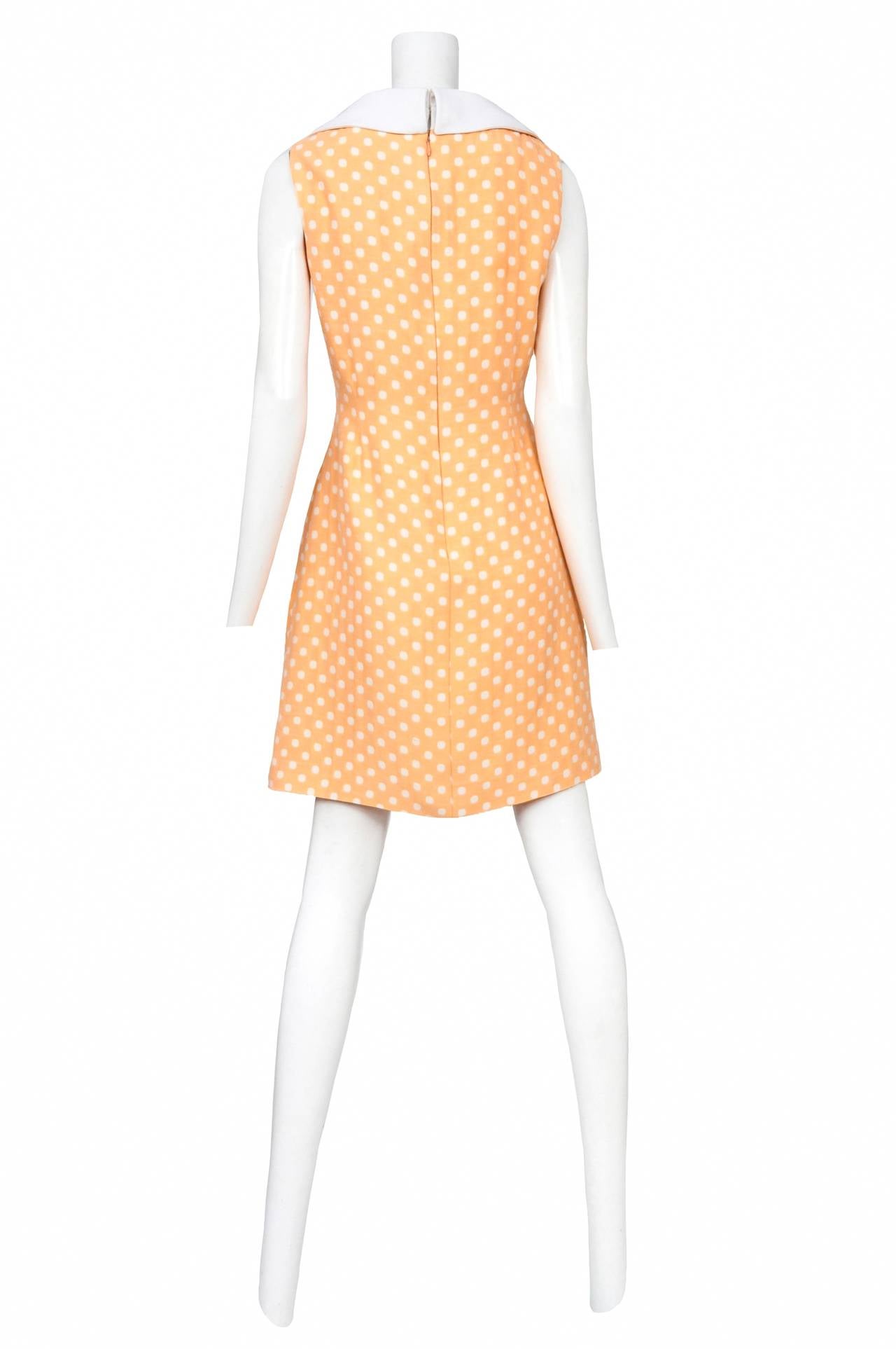 Vintage Pierre Cardin peach and white polka dot wool sleeveless dress featuring white trim at collar and side pockets with a center back zip.