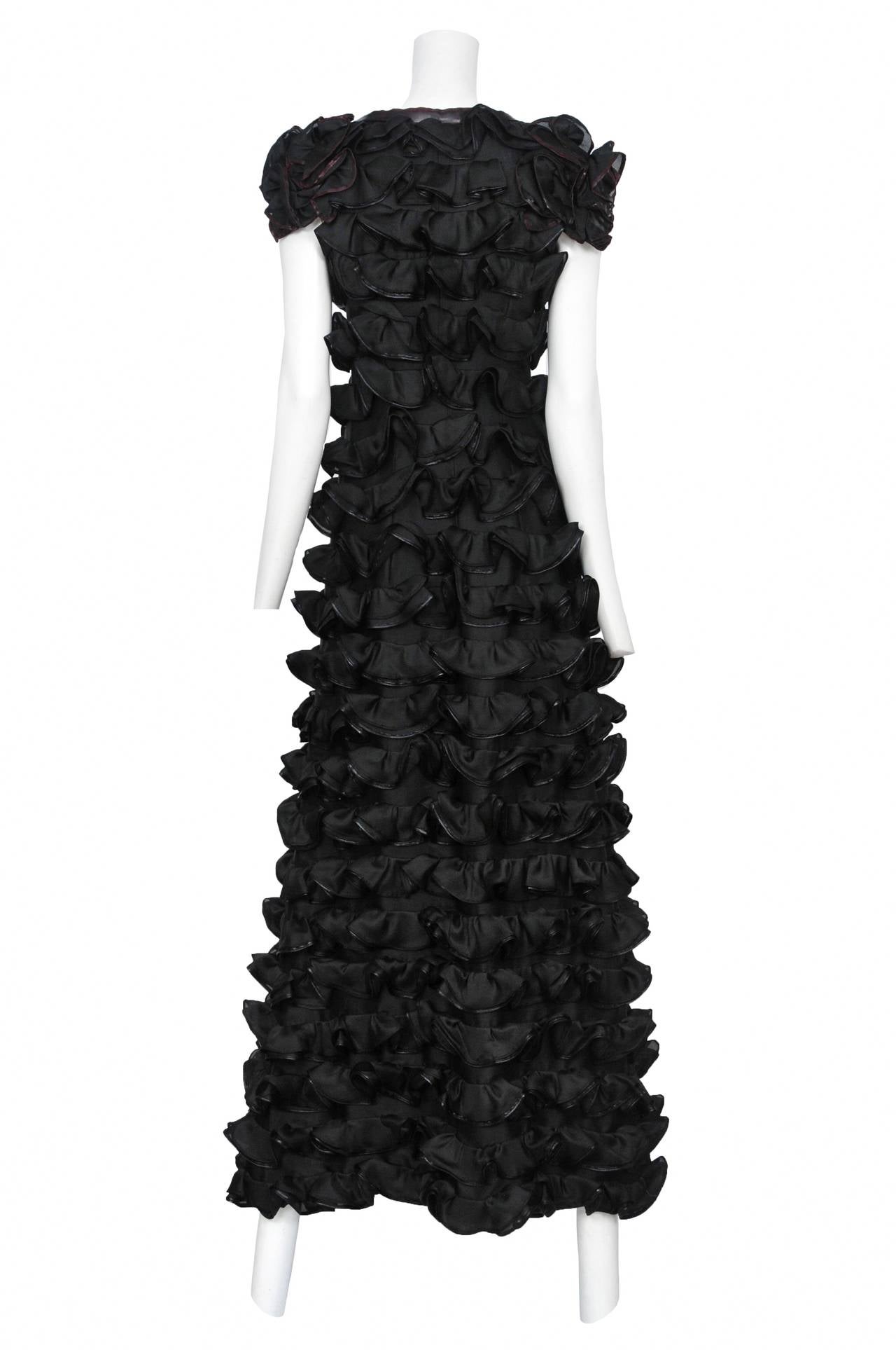 Courreges black organza maxi dress with cap sleeve. Featuring a v-neckline, tiered ruffles throughout and bows at chest and waist.