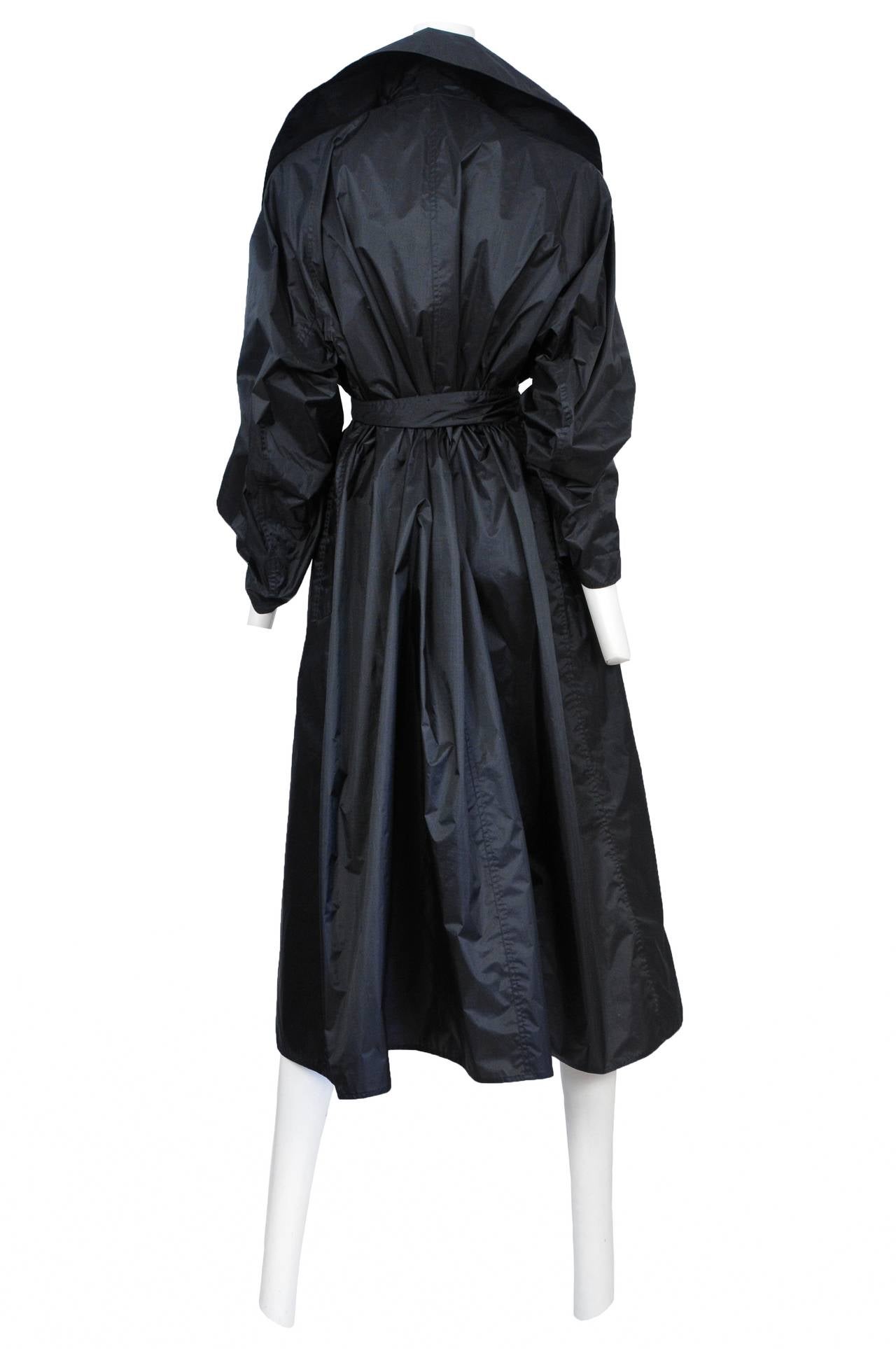 Vintage Azzedine Alaia black double breasted paper thin trench coat featuring a wide lapel and matching waist sash.