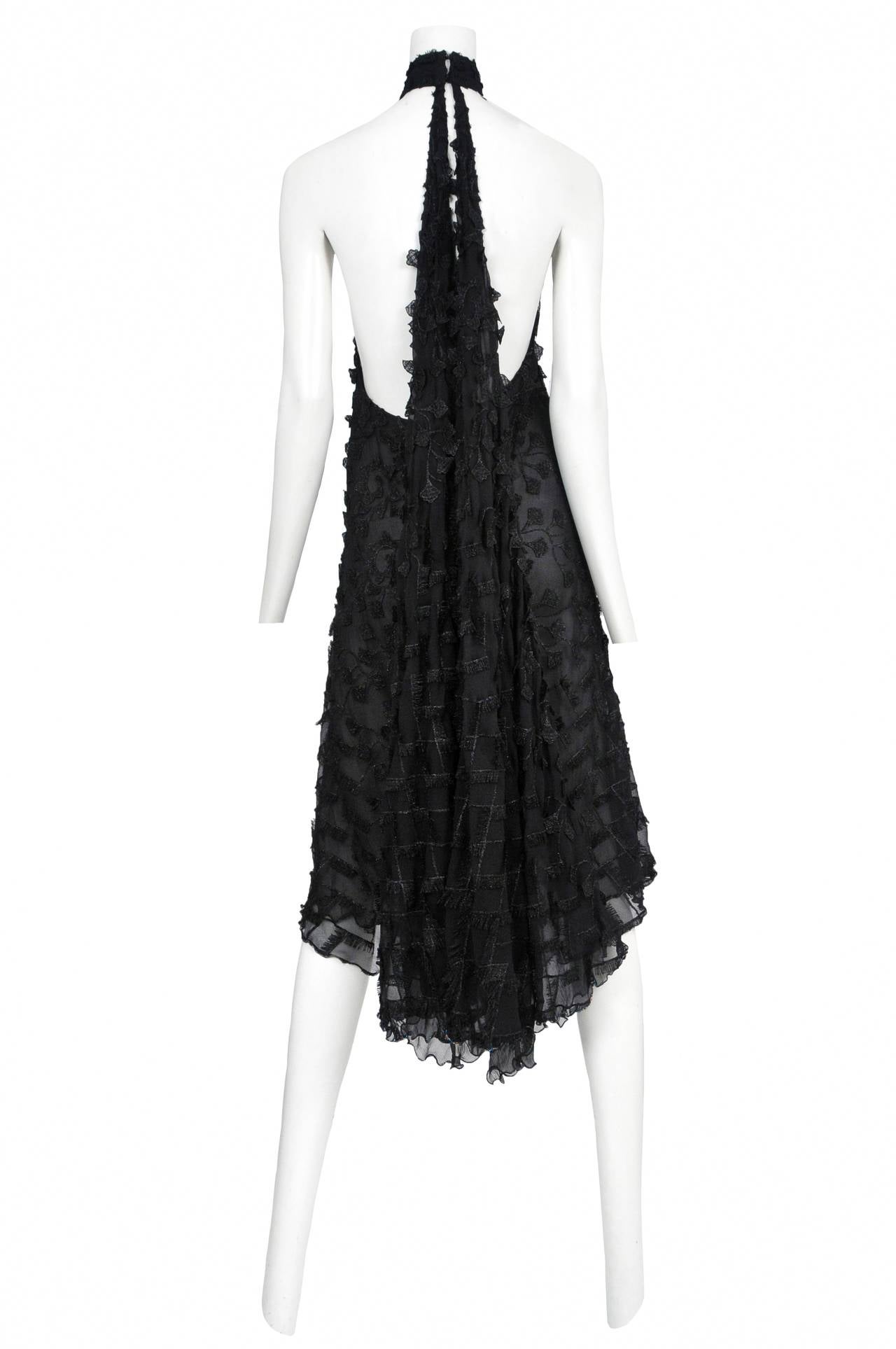 Black silk chiffon halter dress with lurex embellishment throughout.  Attached chain detail at front and cape attachment on back.