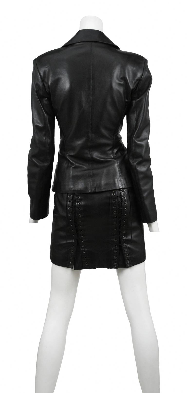 Butter soft black leather 2pc. With classic blazer jacket with signal button closure and fitted through waist. The skirt is a classic mini front and  vamping corset lace detail up both back seams.