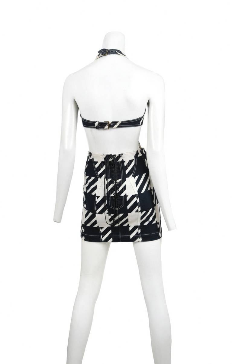 Tati print ultra mini cut away dress. Halter neckline and corset lace closure at back.
