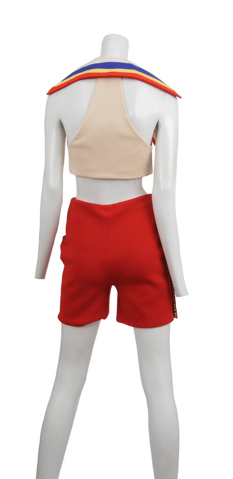 Vintage Gianni Versace off white and red double knit two piece ensemble. Fitted off white crop top with large mulit-colored striped pointed collar and red signature Versace buttons at front. The back of the top features a revealing open racer back