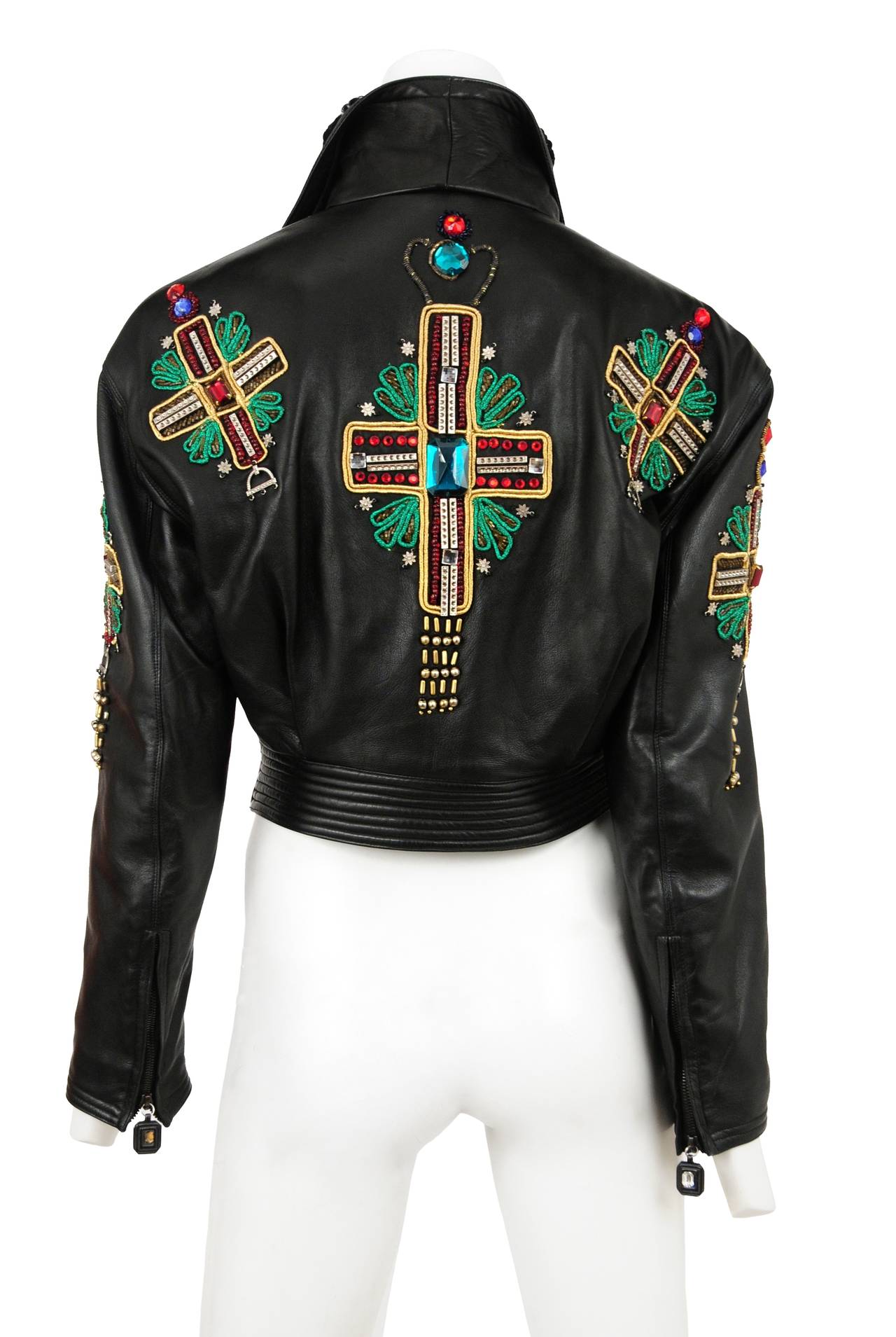 Gianni Versace Iconic leather cropped motorcycle jacket with embellished jeweled cross emblems and mongolian fur collar. Lining is quilted in silk satin.