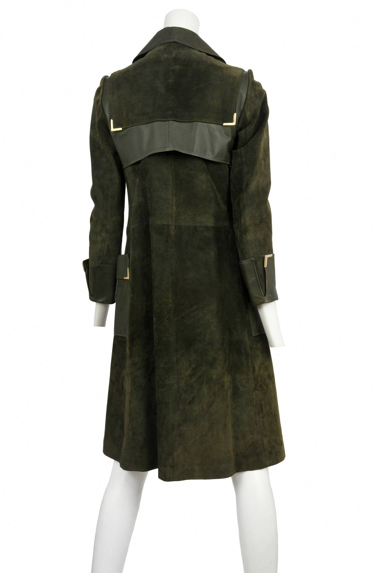 Gucci 1970s olive green suede double breasted coat with dark green leather accents, Gucci enamel buttons and gold hardware trim at collar & pockets. Jacket is completely lined in silk horse bit damask.