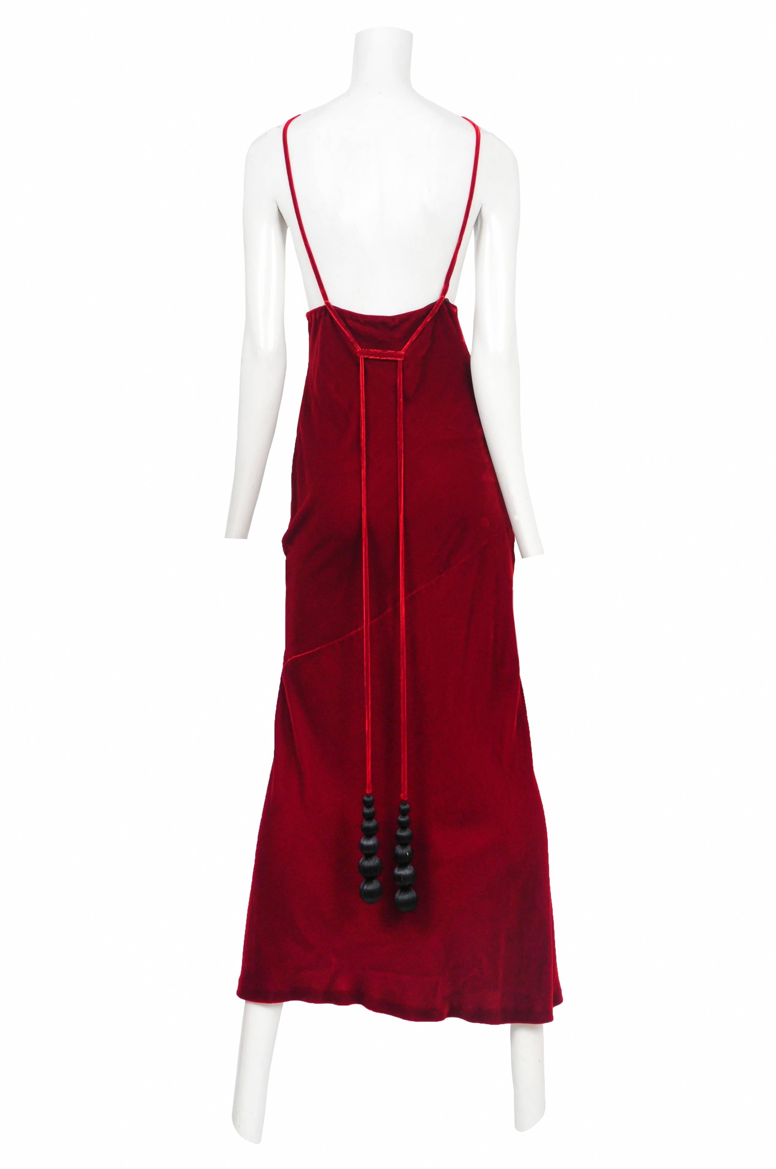 Vintage Jean Paul Gaultier red velvet bias slip dress featuring a deep v-neckline, spaghetti straps and black ribbon covered tassel balls that hang from the back.